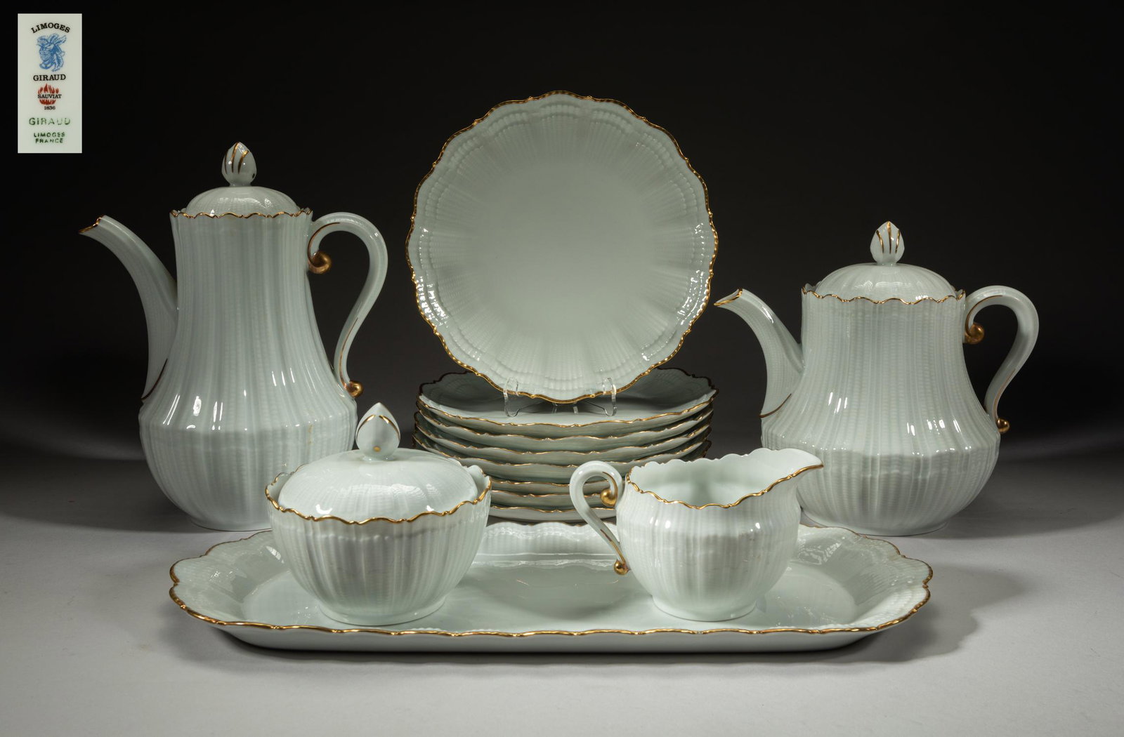 Limoges France Giraud Sauviat Porcelain: Including two tea pots, a creamer and sugar bowl set with a tray, and eight plates, the white glazed porcelain ware with golden-colored rim, each base marked Limoges Giraud France Sauviat. 15.7inch L,
