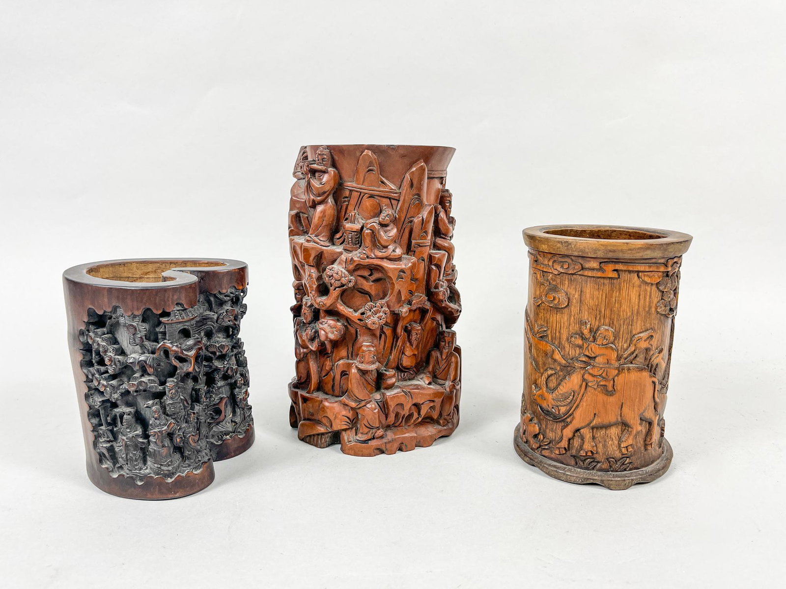 Set Chinese Vintage Brush Pots: Group of three vintage type wood brush pots, one carved around the exterior in high relief with eight immortals in landscape, one with figures in various activities in landscape, the other with a boy 