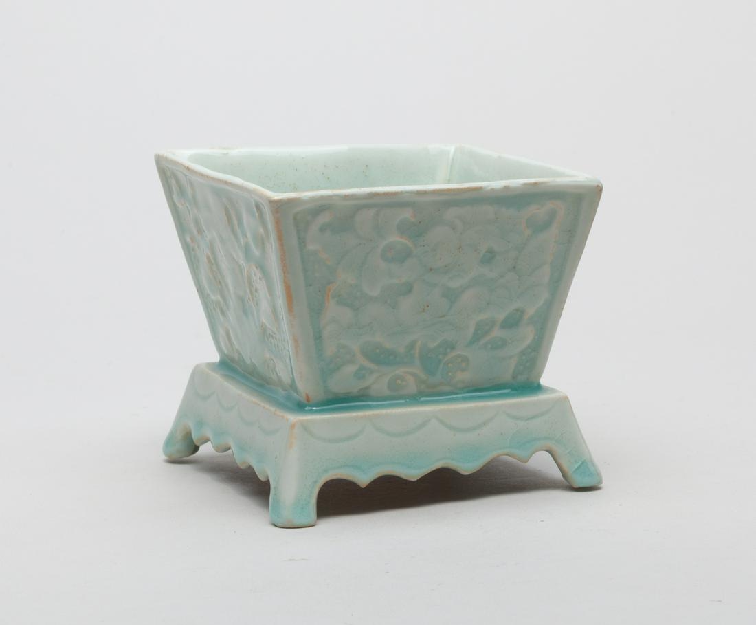 Chinese Hutian Ware Porcelain Brush Washer: Of square section resting on spreading foot, each side incised with a body standing above blooming flowers, covered overall in a pale sea-green glaze stopping at the bottom. 3.8inch L, 3.8inch W, 3.4i