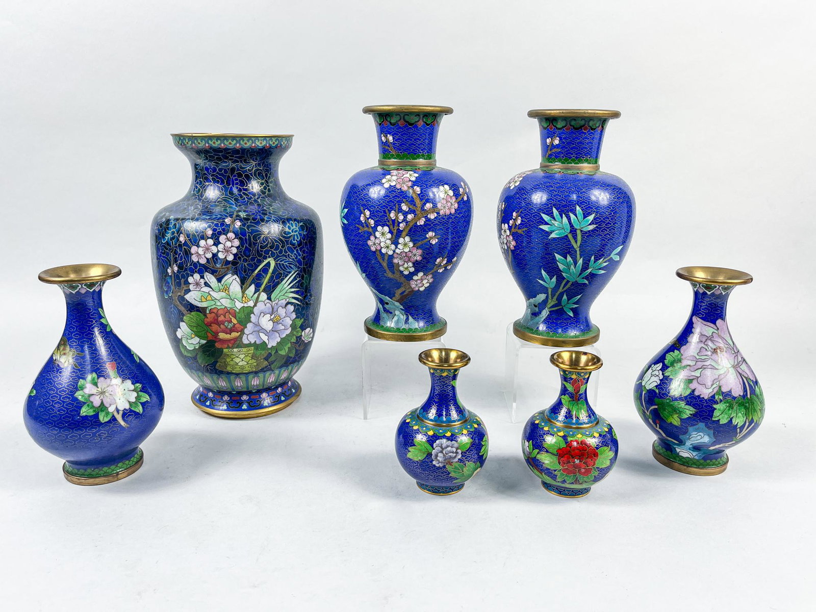Chinese Export Cloisonne Vase: Group of 7 cloisonne vases in ovoid or pear shape, each enameled with traditional Chinese floral patterns against deep blue ground, the interior applied with turquoise glaze or covered in brass. 10.1i