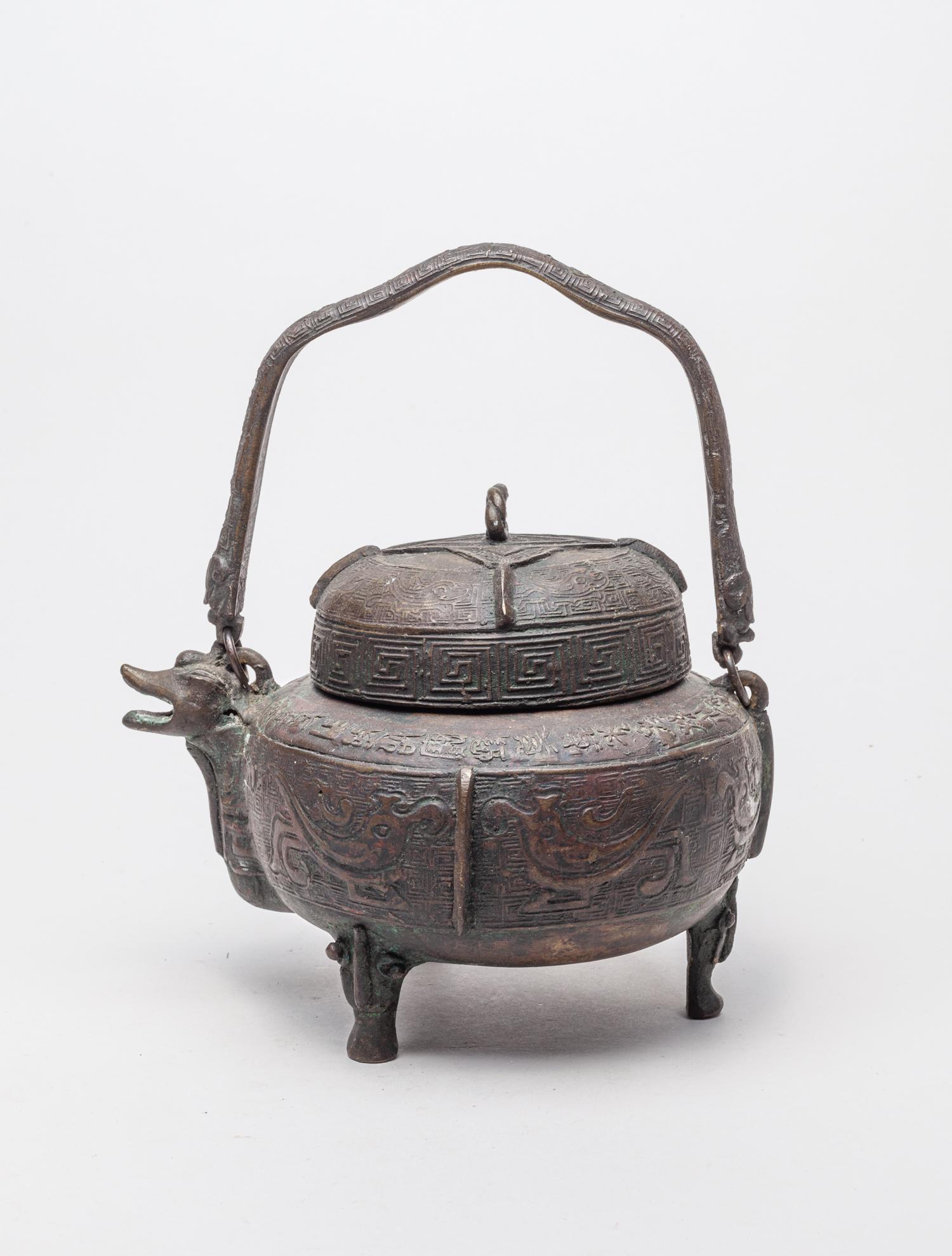 Korean Joseon Type Bronze Covered Pot: The compressed globular body supported on three beast cabriole legs, cast with pairs of archaic birds divided by vertical flanges, the cover and handle cast with similar birds, all reserved against a 
