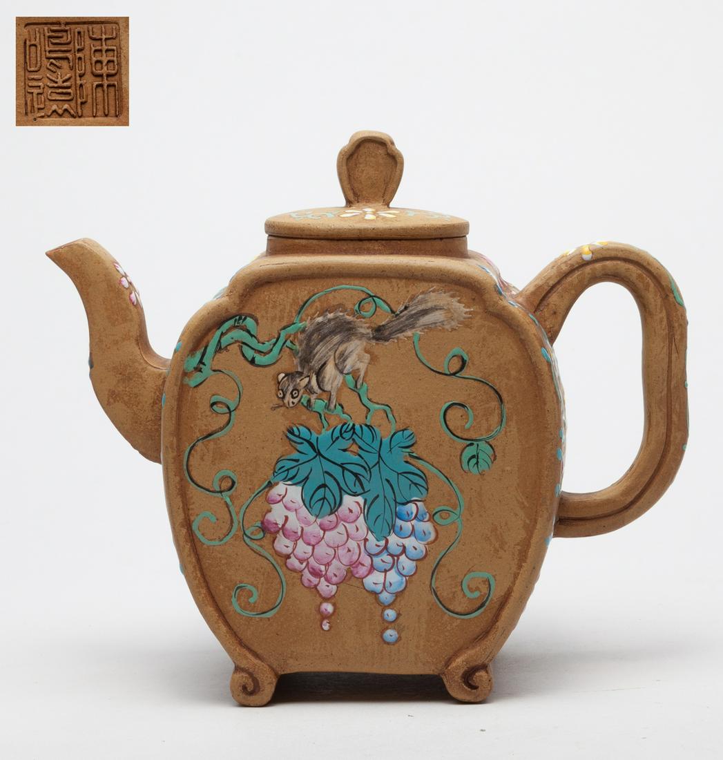 Chinese Enameled Zisha Tea Pot: Enameled to both sides with a squirrel clambering on grape vines issuing fruits and scrolls, the other sides, handle, and spout enameled with flower scrolls, the cover interior incised with two marks