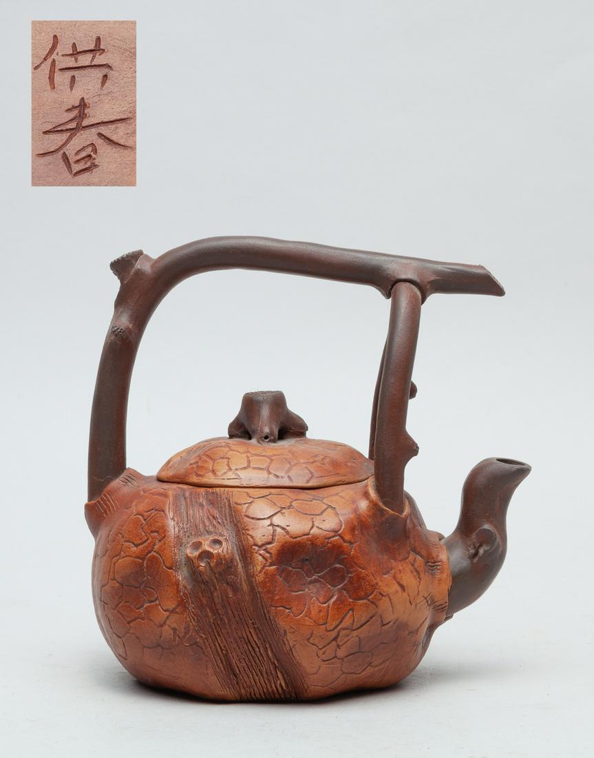 Special Form Chinese Zisha Tea Pot: The pot moulded in trunk form, the body and cover carved with crackled patterns, the bottom inscribed with two characters . 6inch H, 5.6inch L, 4.6inch W.