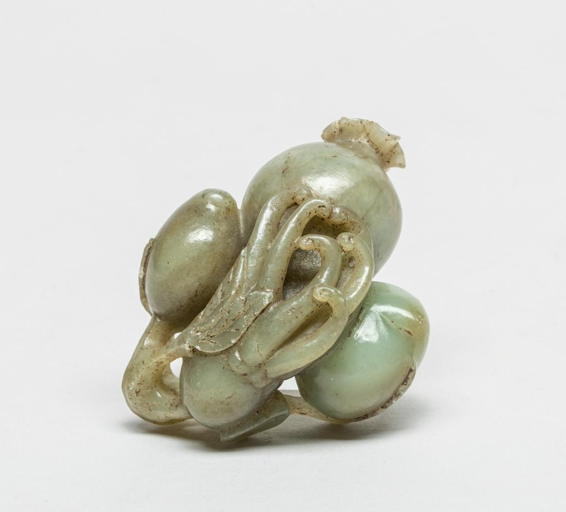 Large Chinese Grey Jade Fruits: Carved in openwork with a pomegranate, a buddha hand and two peaches borne on a gnarled leafy branch, the stone in celadon tone with grayish inclusions. 3.4inch L, 2.7inch W, 1.6inch H.