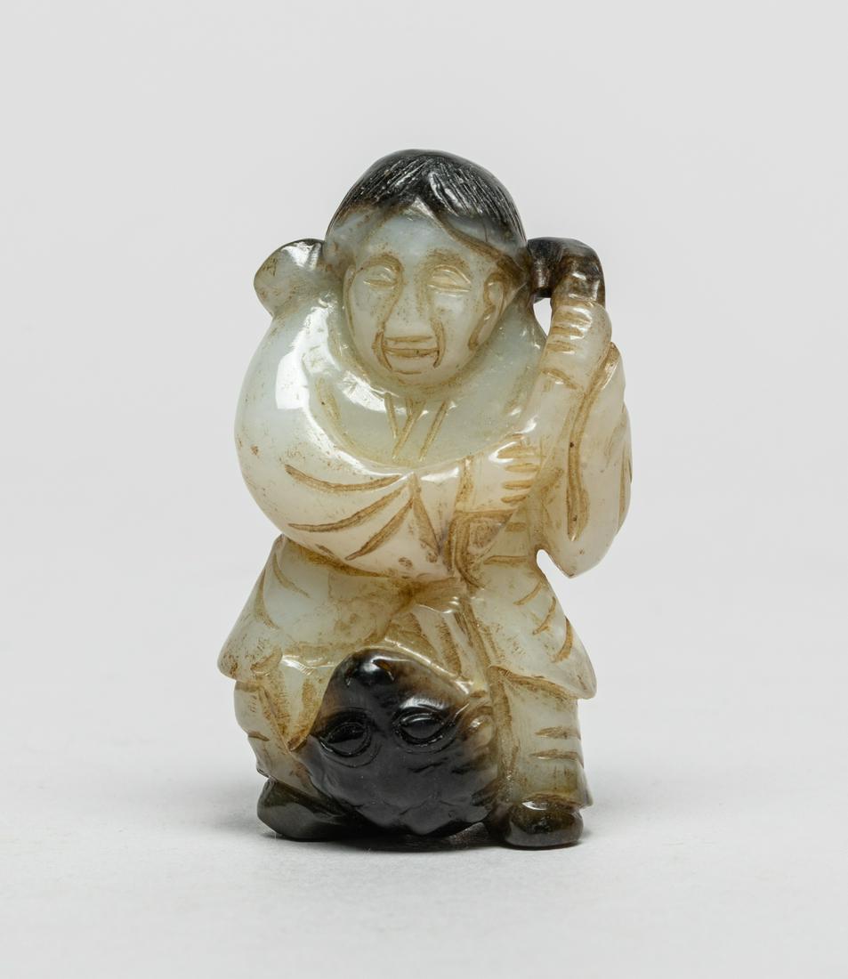 Chinese Ming Type Jade Boy: Carved as a man with hands holding a lingzhi branch, a toad clambering on his legs, the stone in a variegated white and black tone. 2.05inch H, 1.18inch W.
