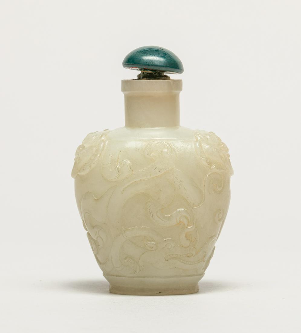 Chinese White Jade Snuff Bottle: The white jade molded in ovoid form, carved to both sides with archaistic beasts with sinuous body and ferocious expression , flanked by a pair of faux-ring beast mask handles, with a glass stopper. 3