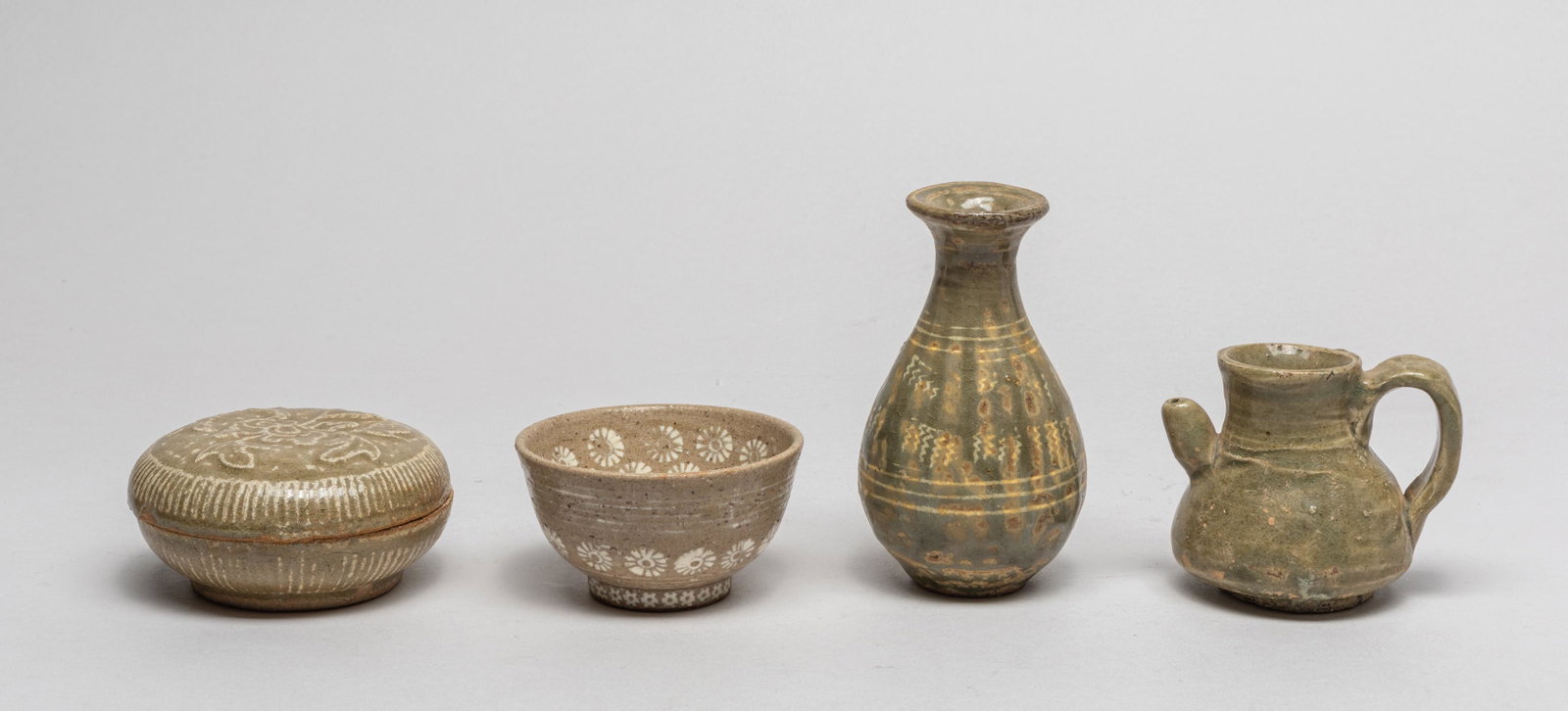 Korean Shipwreck Porcelain Sets: Including a pot, a covered case, a cabinet vase and a pot, the bowl and case decorated with floral patterns, applied with glaze in olive-green and beige tones. 4.2inch H, 2.4inch W (largest).