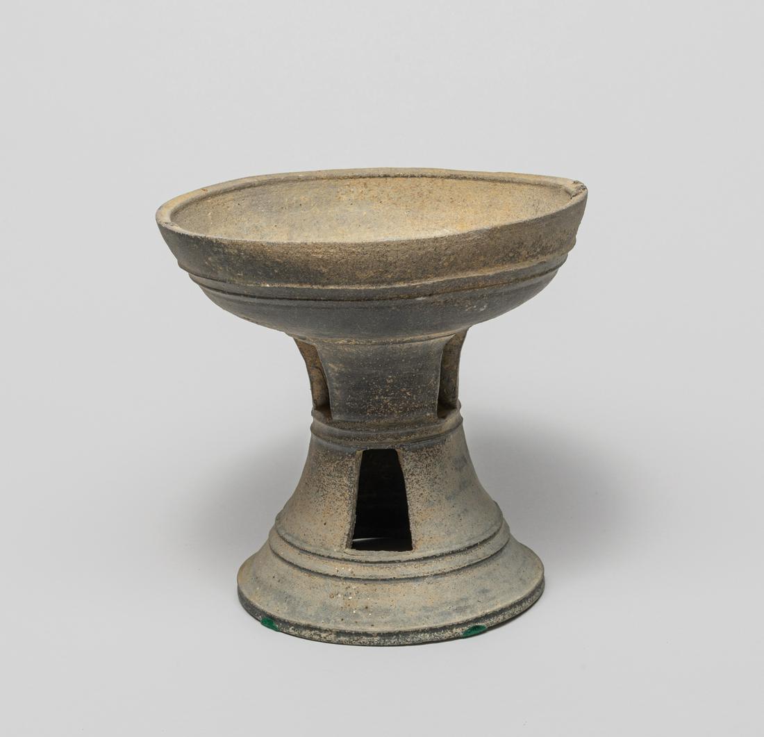Rare Lg Korean Joseon Pottery Oil Lamp: Rare quality Korean early Joseon carved gray pottery oil lamp, the hollow waisted body rising a shallow bowl, set with three twin parallel registers. 6.75 inch H; 7 inch W.