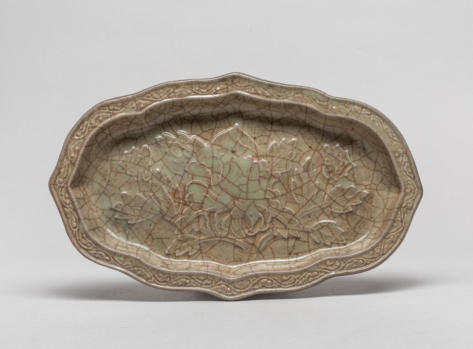 Chinese Shipwreck Yue Type Porcelain Washer: Of ruyi head shape, the interior carved with blooming peony and the rim with meandering foliage, covered overall with a mottled olive-green glaze suffused with a network of brown crackles. 10.5inch L,