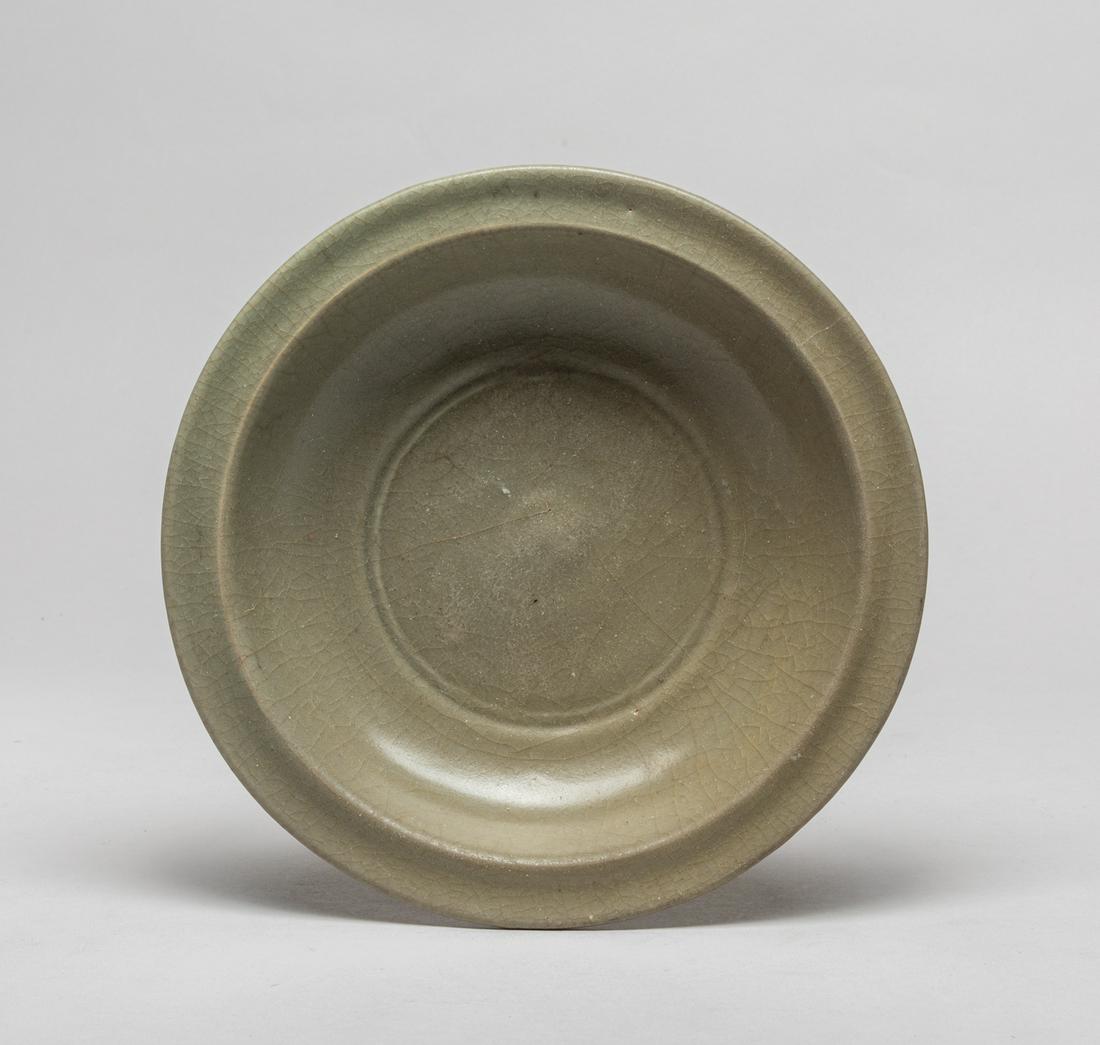Korean Early Shipwreck Porcelain Plate: The shallow rounded sides rising from a short tapered foot to a flat rim, Overall covered with a grayish celadon glaze suffused with a network of natural crackles, stopping at the footring. 8.1inch W,