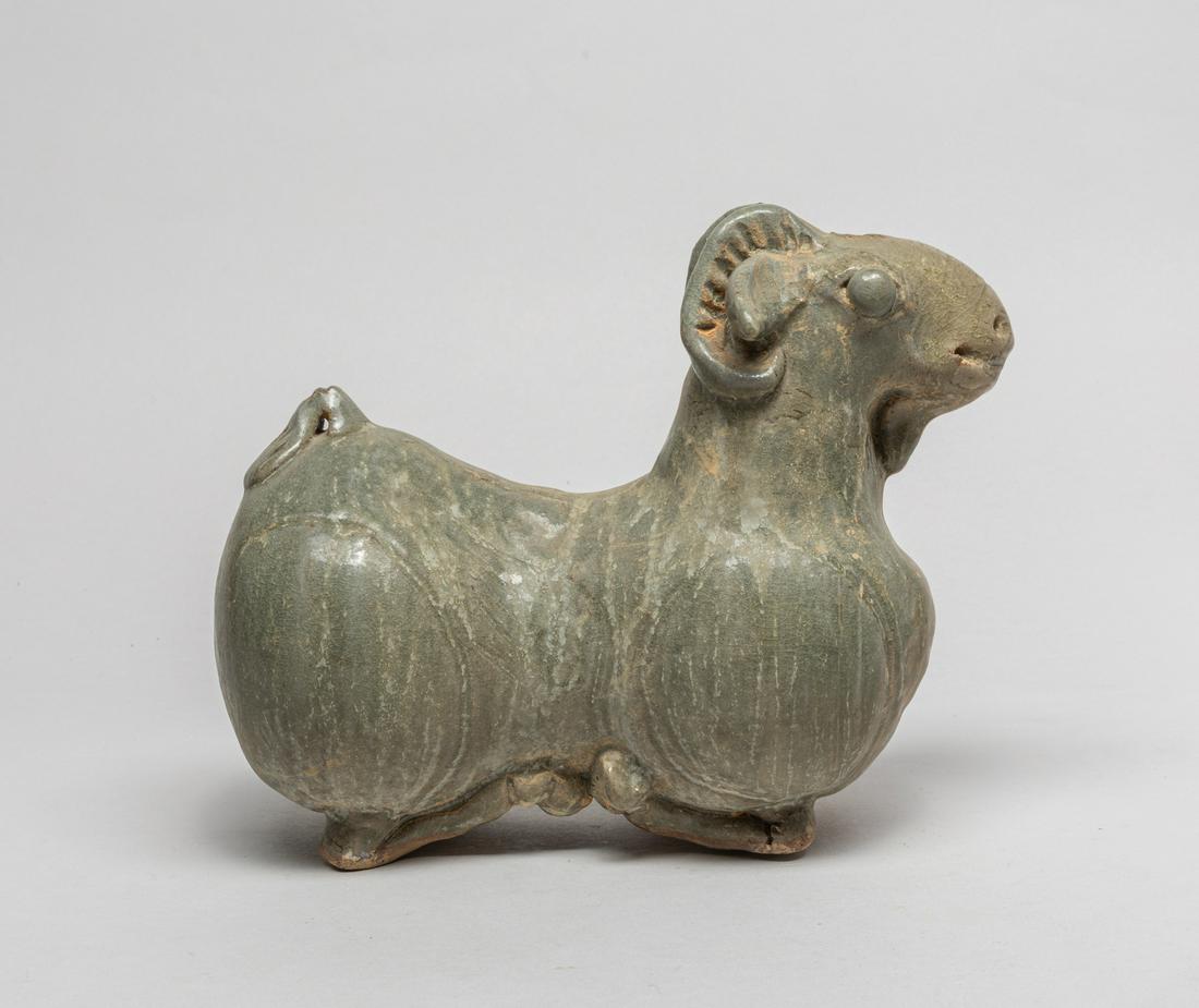 Large Korean Early Porcelain Sculpture: Modeled in the form of a recumbent sheep, its four legs tucked beneath its body, detailed with bulging eyes and pierced nostrils, pierced at the head top. 8.8inch L, 4.2inch W, 7inch H.