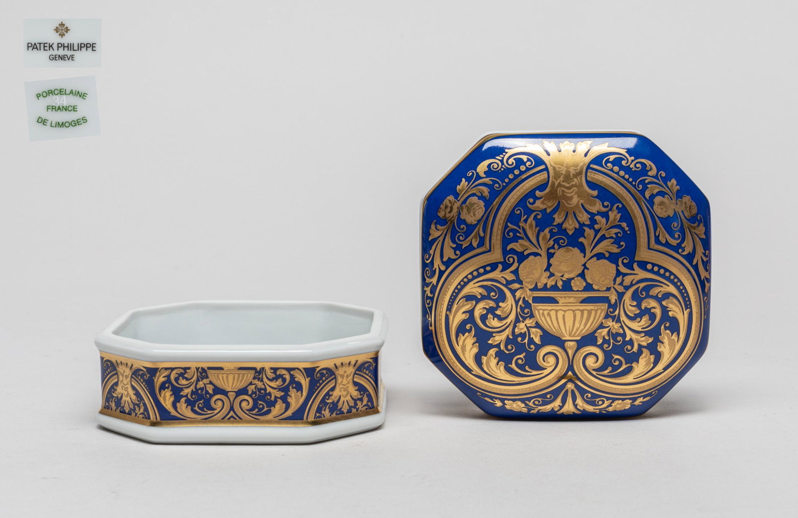 Patek Philippe Porcelain Covered Box: The box cover and sides decorated with classical foliage patterns in golden color on a blue ground, the bottom marked Patek Philippe Geneve Porcelaine France De Limoges Collection 2000. 2.35inch H, 3.