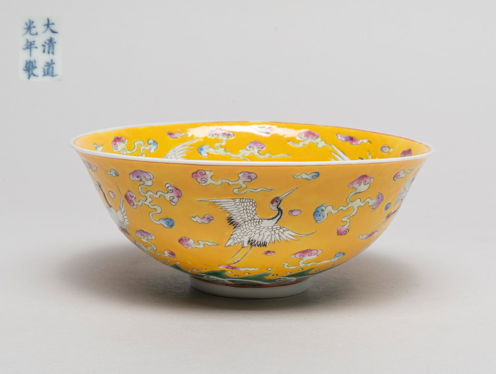 Large Chinese Enameled Porcelain Bowl: Vividly enameled with four cranes on the interior and five cranes on the exterior among cloud scrolls and above waves, the interior centre with a medallion of three peaches, all reserved on a bright y