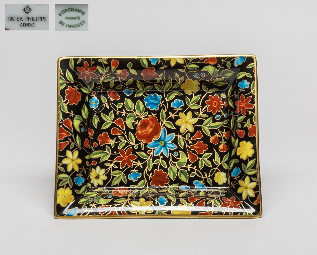 Patek Philippe Porcelain Flower Plate/Tray: Of rectangular form, the inside decorated with leafy foliage issuing yellow, red and blue flowers on a black ground, the base marked Patek Philippe Geneve Porcelaine France De Limoges Collection 1999.