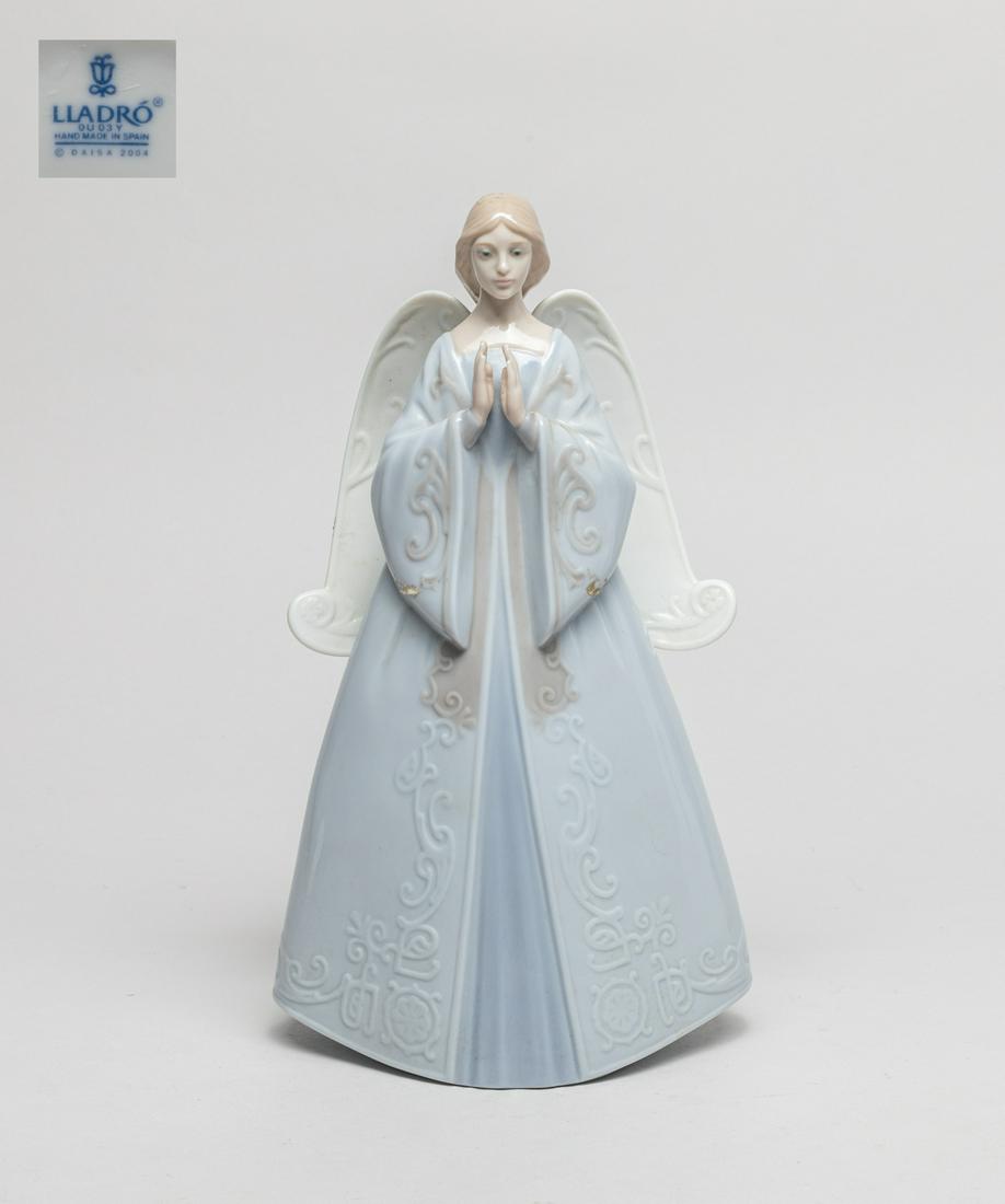 Lladro Porcelain Figure: Modeled as a standing angel dressed in a long loose robe, the base marked LLadro Hand Made in Spain. 9.5inch H, 5.3inch L, 3.5inch W.