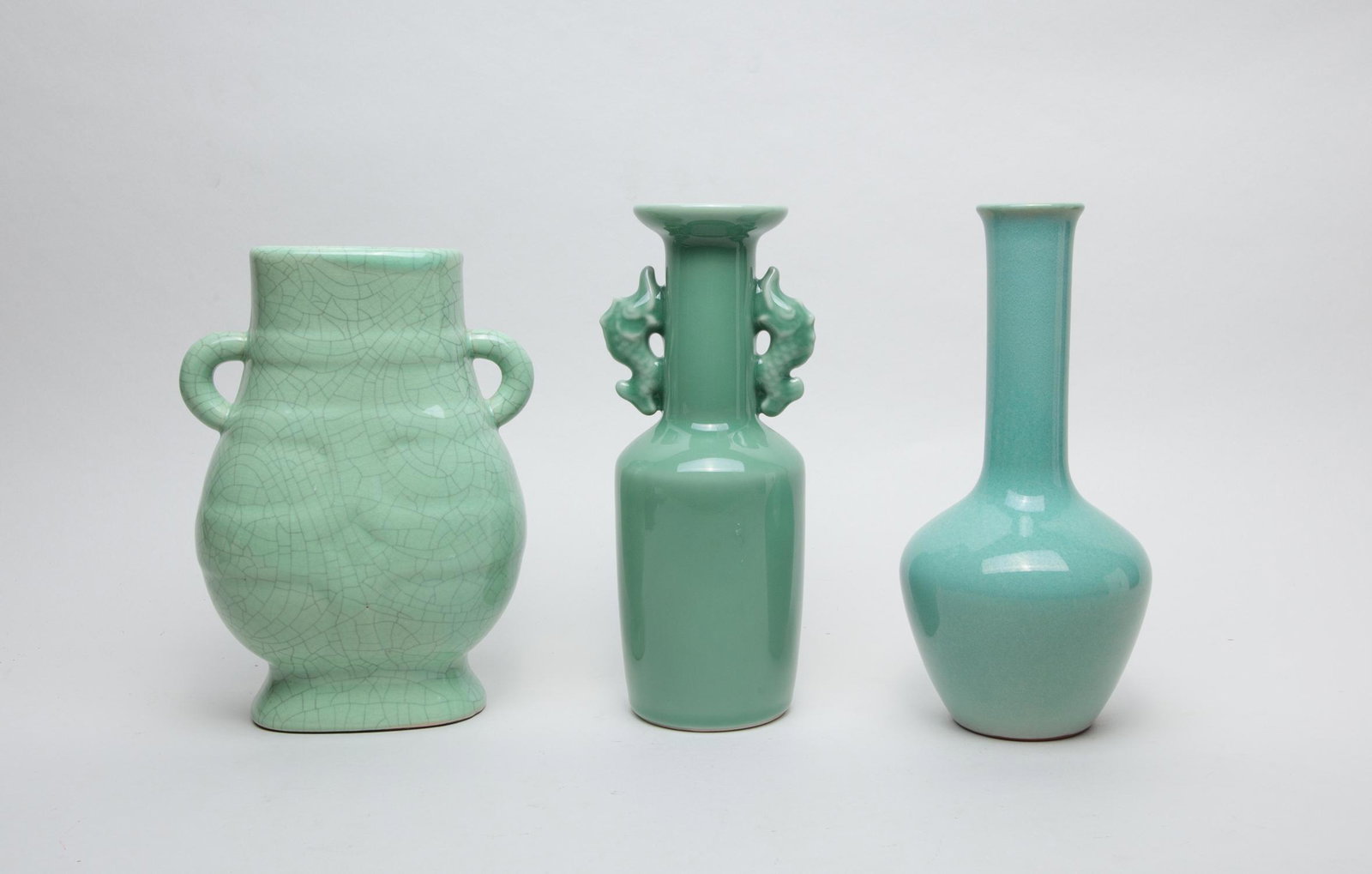 Estate Chinese Export Porcelains: Three porcelain vases applied with sea-green glaze, one of ovoid from with a tall neck, one of columnar form with a cylindrical neck and a flared rim, set with a pair of fish handles, the other of com