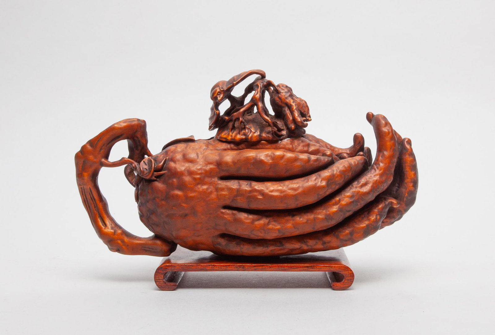 Chinese Wood Carved Buddha Hand Pot: Naturalistically carved in buddha hand form, a bat clambering on the cover, with a wood stand. 8.6inch L, 4.65inch H, 3.4inch W (w/o stand).