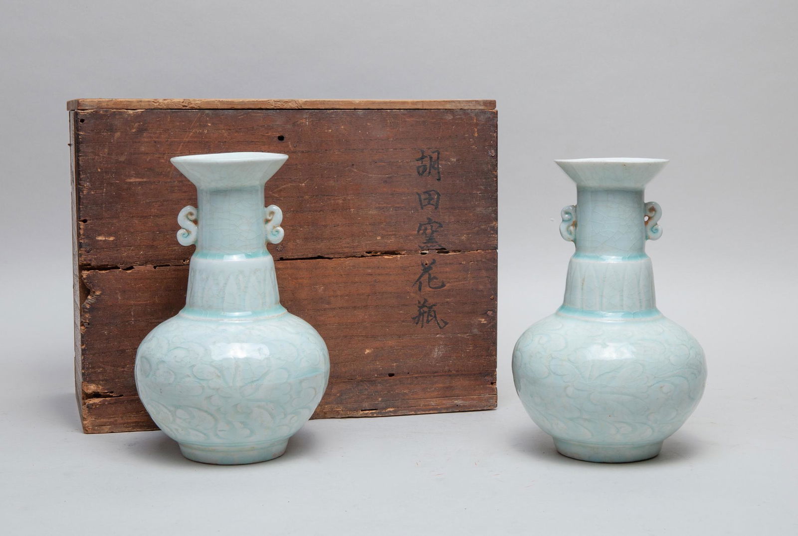 Pair Chinese Celadon White Porcelain Vase: A pair of Chinese export celadon white glazed porcelain vase, with beast handles, decorated with flowers, with box. 7.5 inch H; 4.75 inch W (vase size).