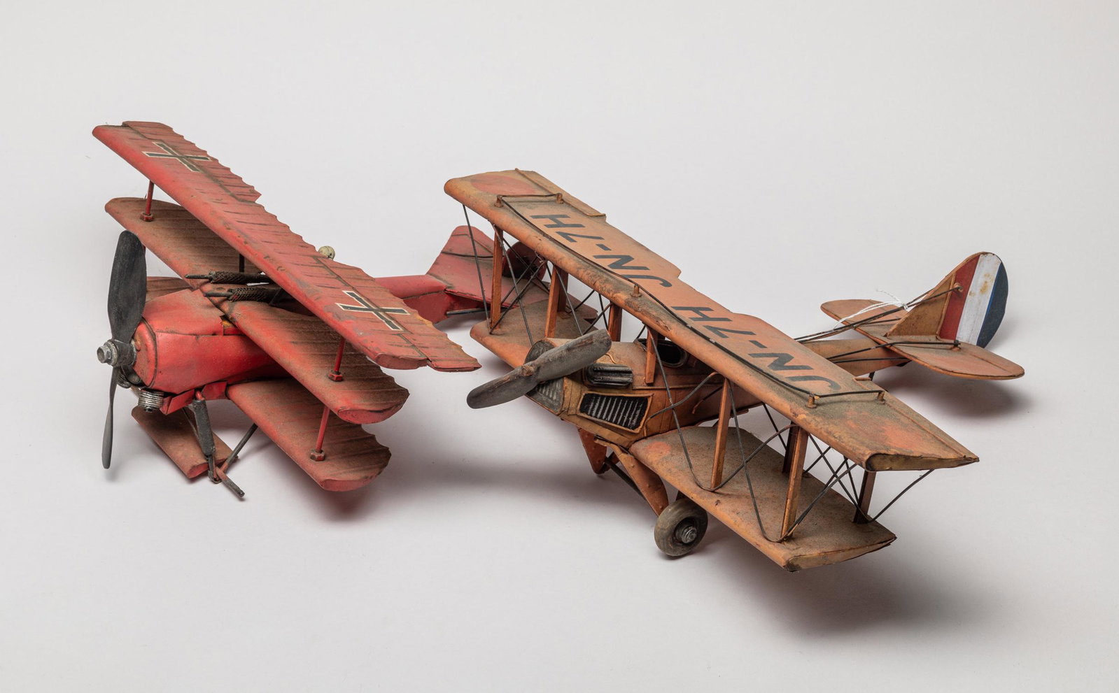 WW1 Metal Plane Model: Two World War I type vintage metal plane models, one with a cross symbol and the other marked JN-7H. 17inch L, 13.5inch W, 6inch H (larger).