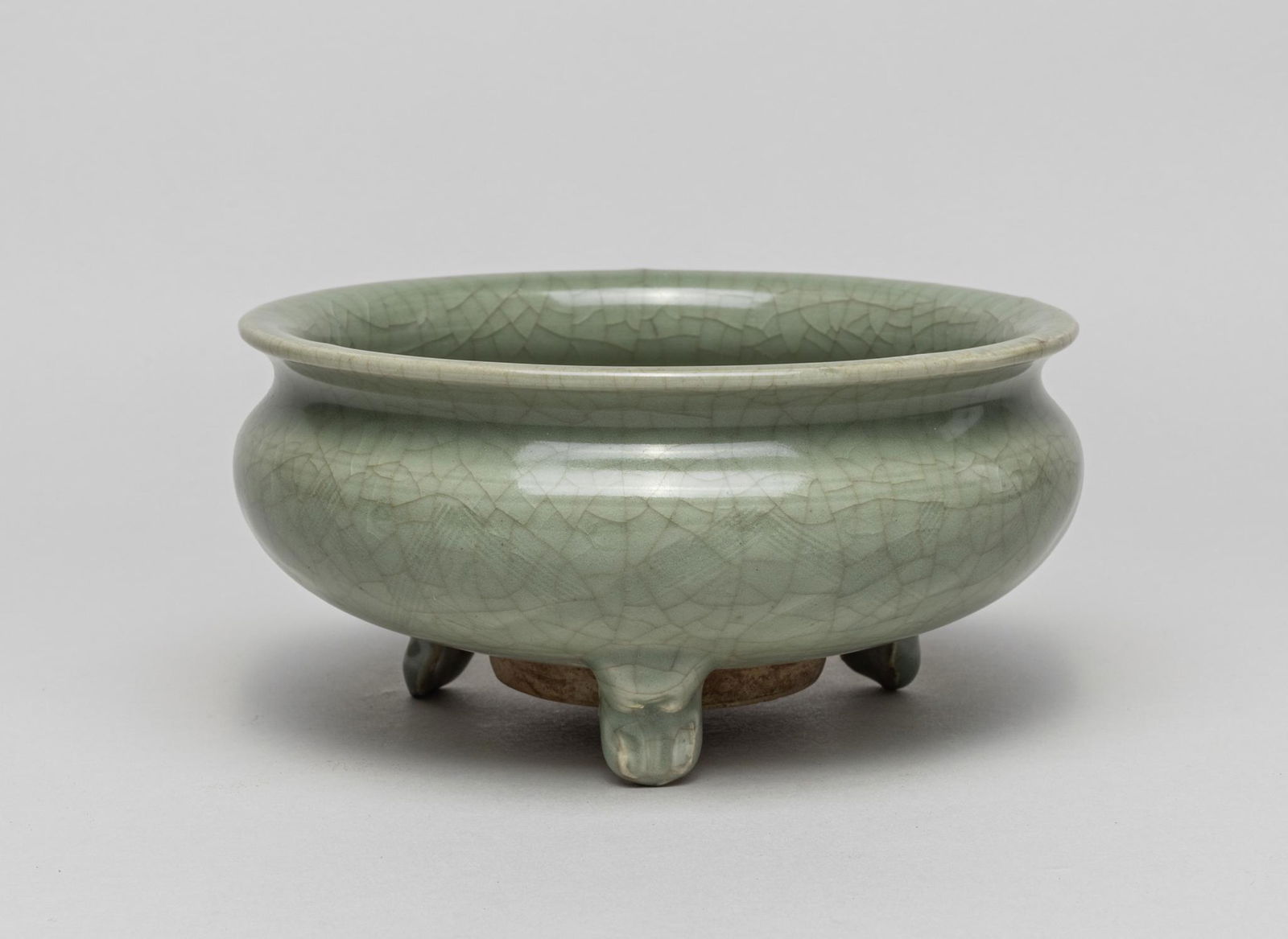 Rare Korean Celadon Porcelain Censer: The compressed globular body supported on three beast paw feet, rising to a waisted neck with flared rim, covered overall with a celadon glaze suffused with a network of crackles, polling above the bo