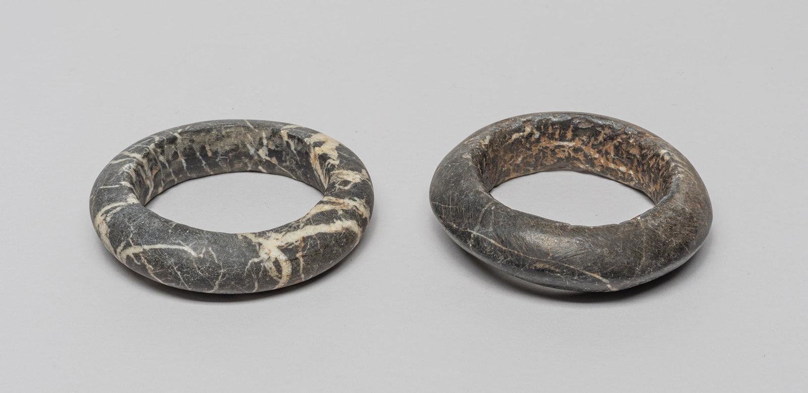 African Antique Hand Carved Stone Bangles: Two rare large African style hand carved stone bangles, the stone in black tone with white streaks. Approx. 4.15inch outer diameter, 2.9inch inner diameter (larger).