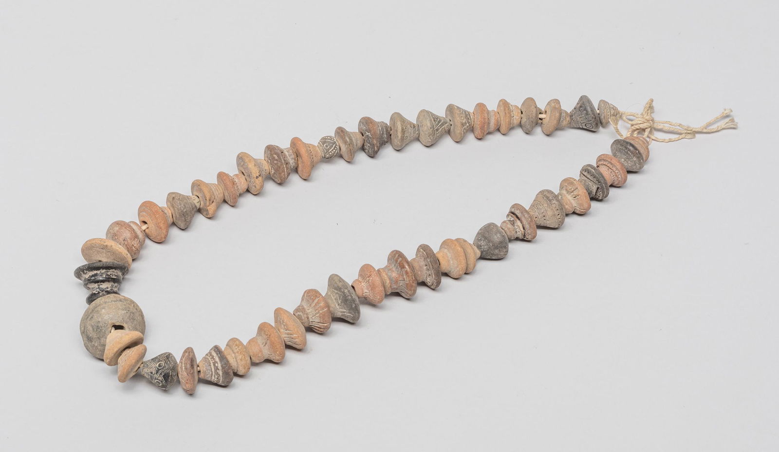 Antique Mali Spindle Whorl Necklace: Collectible African type spindle whorl Mali clay trade bead necklace, the beads incised with abstract motif. 27inch L.