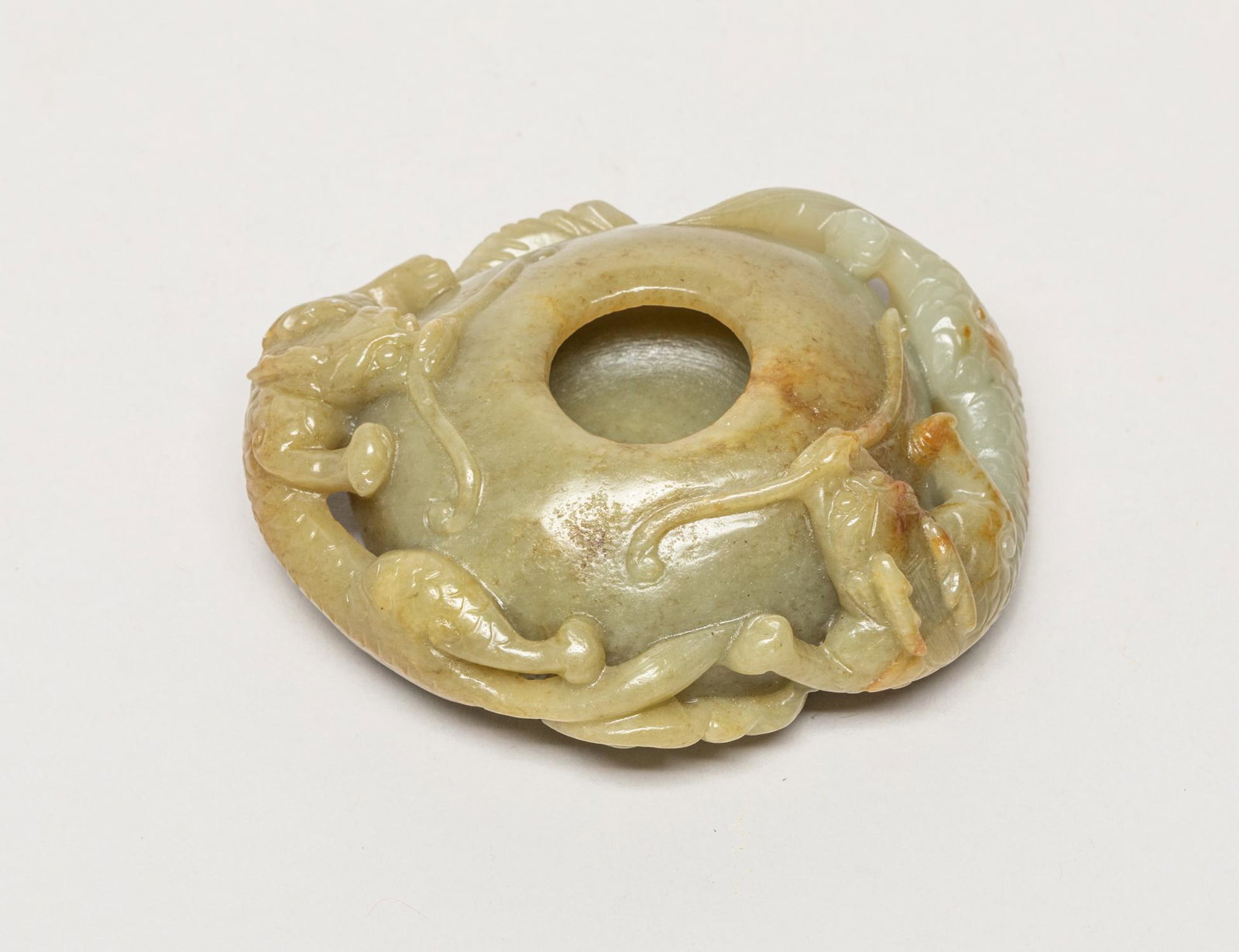 Chinese Russet Jade Dragon Washer: The hollow compressed body surrounded with a pair of openwork clambering dragons among clouds, detailed with long curled beard, bifurcated tail and scaled body. 3.7inch L, 3.2inch W.