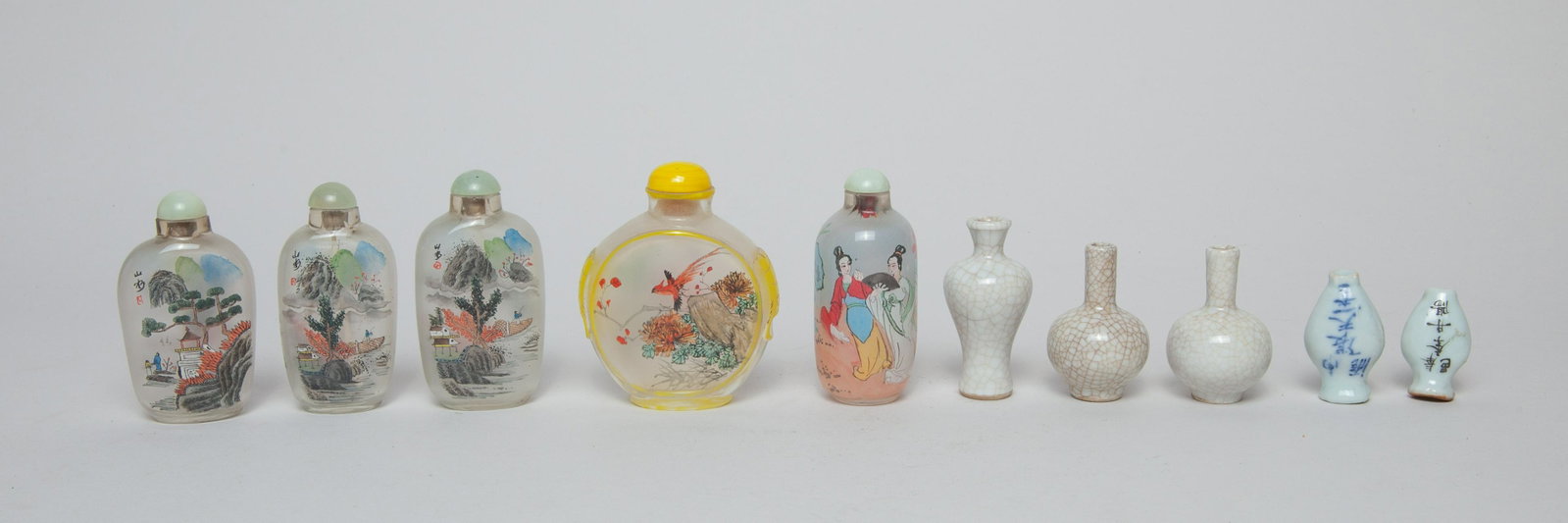 Chinese Porcelain & Glass Snuff Bottles: Including 5 porcelain and 5 glass snuff bottles, the porcelain snuff of vase form, applied with a crackled glaze or inscribed with characters, the glass snuff in flattened, ovoid or rounded form, pain