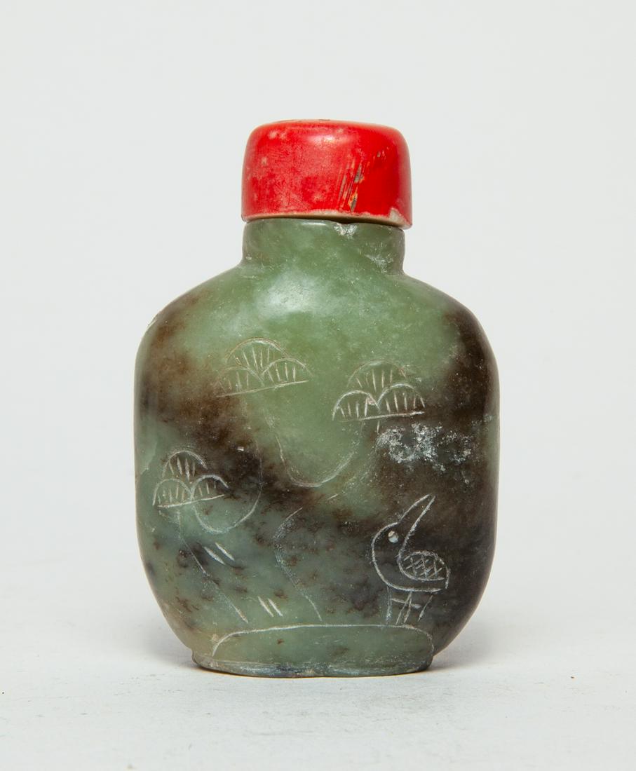 Chinese Old Jade Carved Snuff Bottle: Of rounded square form, one side incised in low relief with a bird beneath a pine tree and the reverse with a pine, the stone in a celadon tone with brown inclusions, with a red stopper. 2.75inch, 1.8
