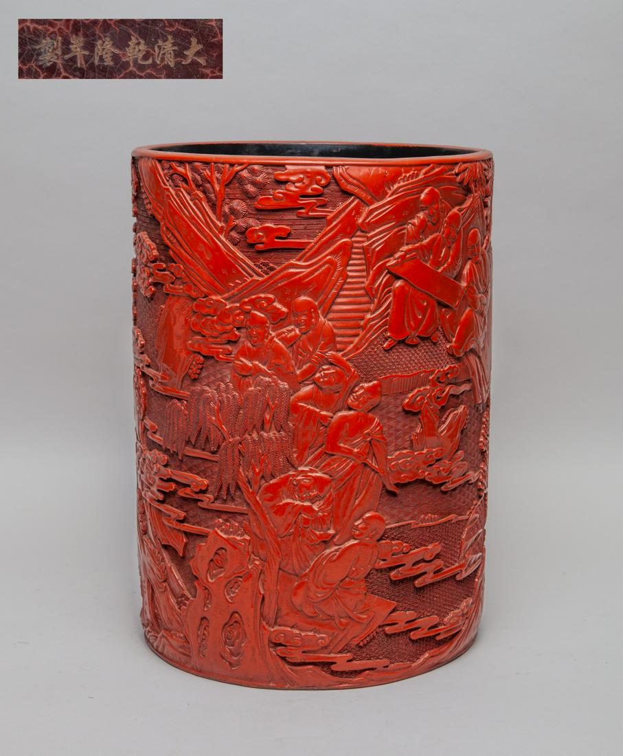 Massive Chinese Carved Cinnabar Brush Pot: Of cylindrical form, the exterior carved with Luohan in landscape on a wave ground. 10inch W, 13.8inch H.