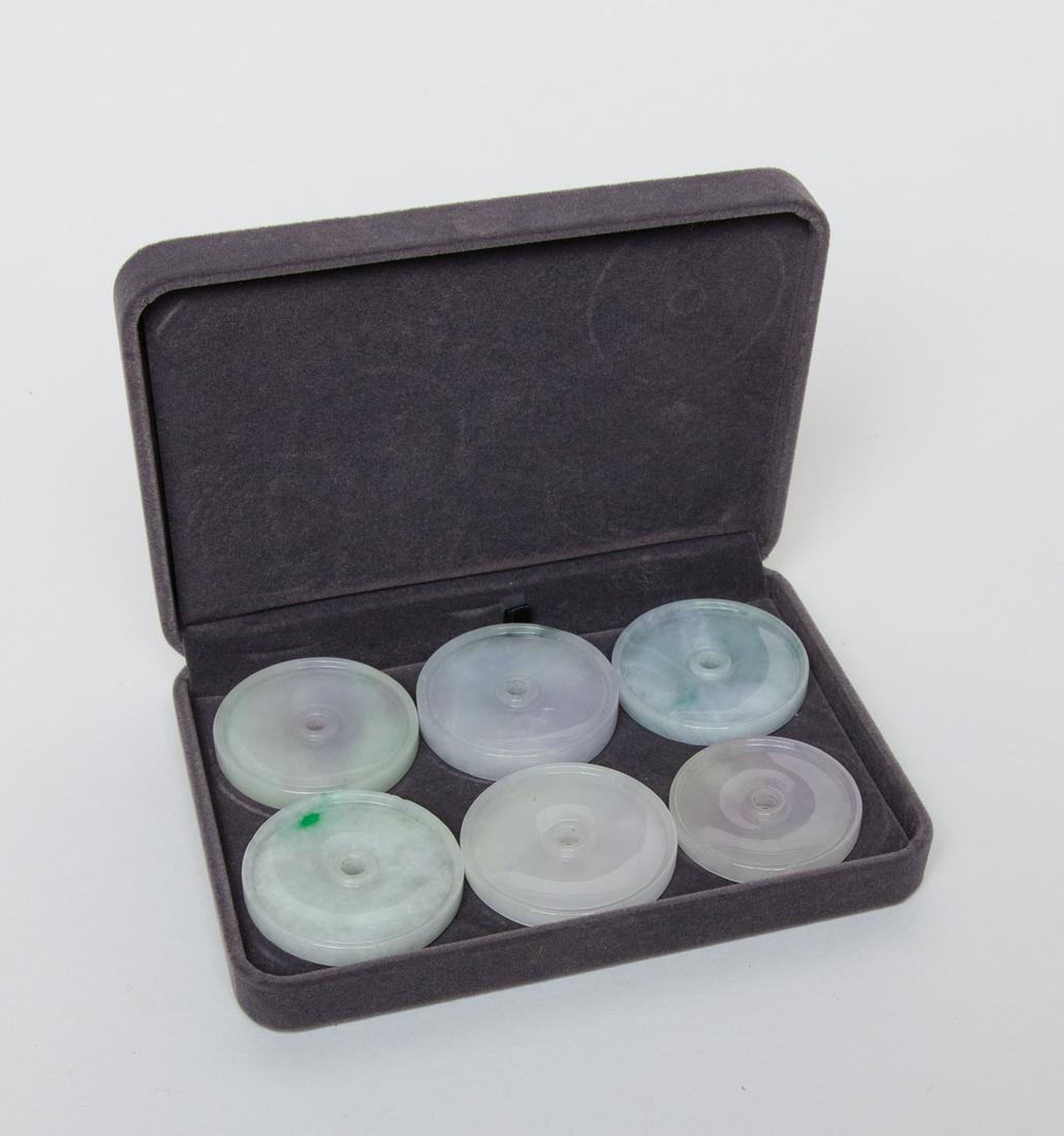 Collectible Chinese Jade Bi: Group of six jade bi in circular shape, each pierced with an aperture at the center, the stone in white or pale celadon tone with apple green or dark green inclusions. 2.12inch W (largest).