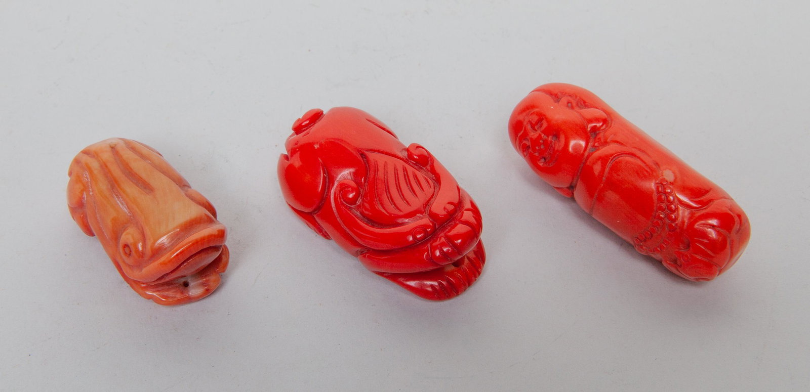 Chinese Coral Like Carvings: Three pieces as a group, carved in the form of recumbent beast, recumbent frog and a Buddha. 2.17inch L, 0.84inch W (largest).