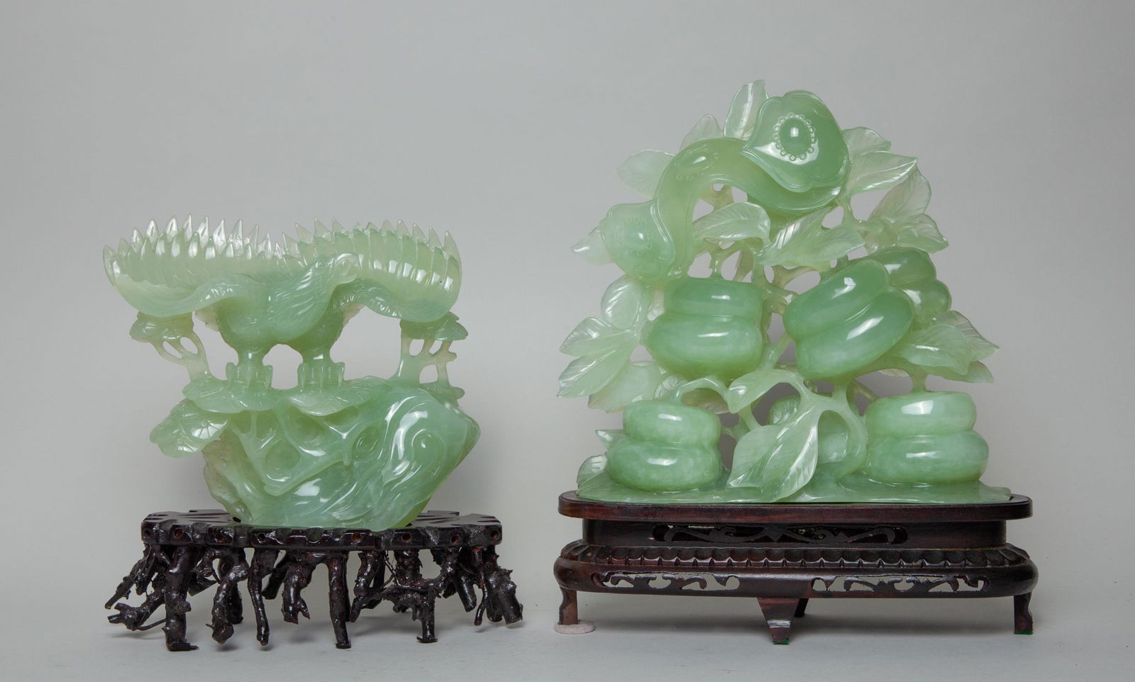Two Chinese Translucent Jade Table Sculpture: One naturalistically carved in openwork of persimmon branch from, the other carved in eagle form, each with a stand. Approx. 11inch H, 11inch W (larger jade only).