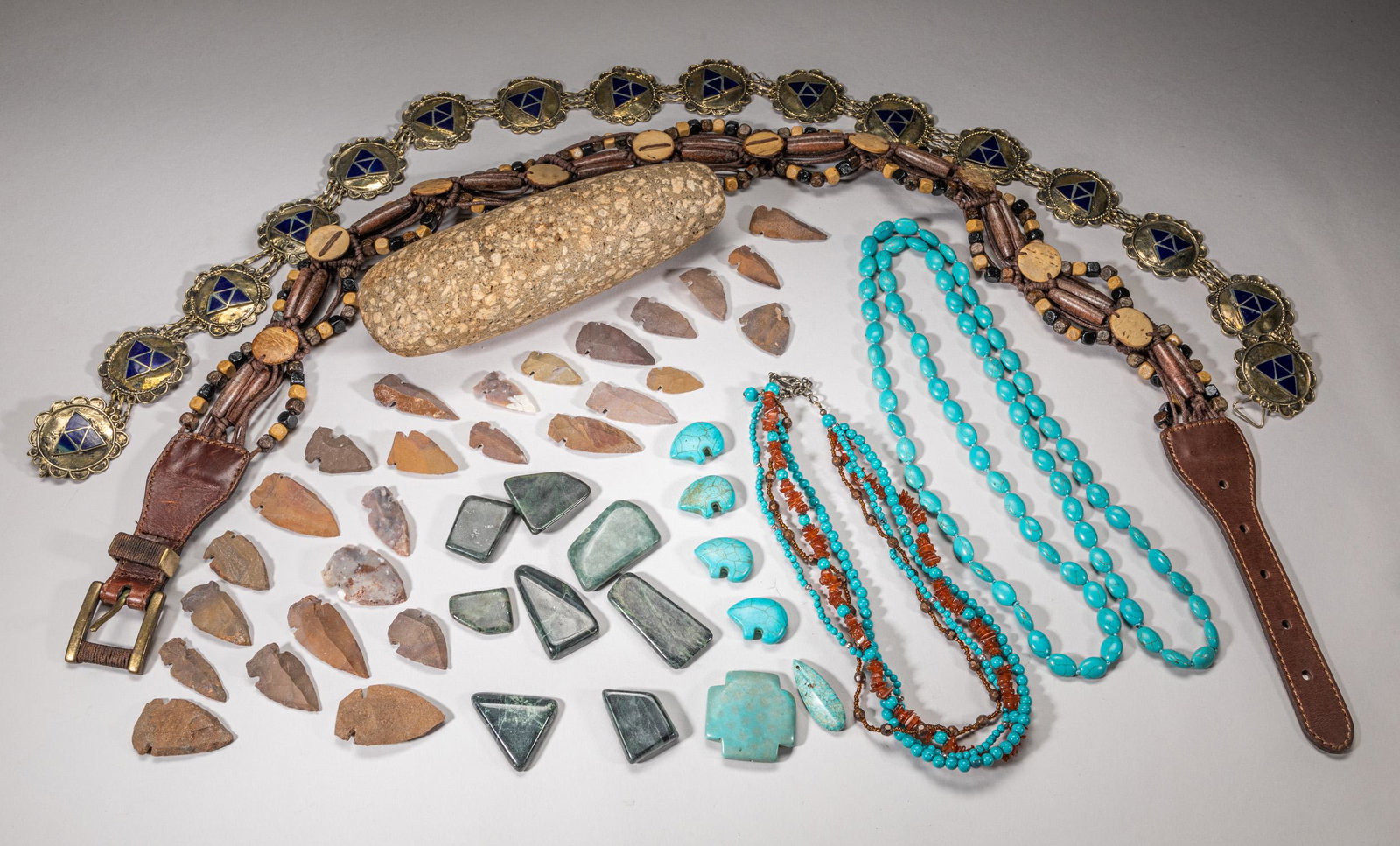 Collectible Zuni/ Navajo Jewelry: Including turquoise like and amber like bead necklaces, spinach jade and turquoise like stone carved toggles, stone carved spear points, a large stone carving, and two Native American style belts. 40i
