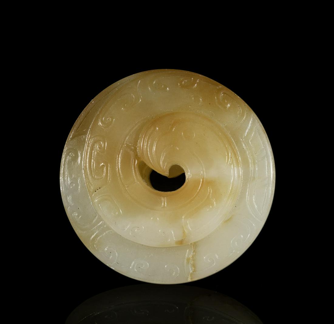 Special Form Chinese Russet Jade Bi: Carved in the form of a flattened coiled long-tailed stylized bird, the stone of a variegated white and brown tone. 2.07inch D. The Estate of Louis H. Sherman. New York, 1992