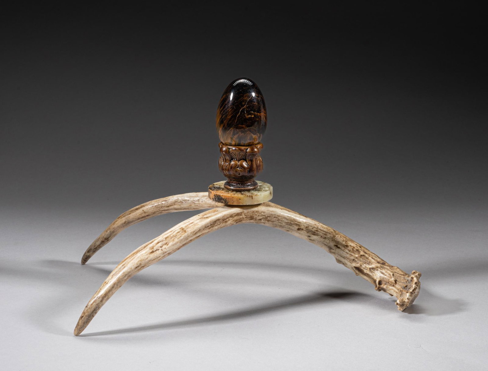 Chinese Horn, Jade & Gemstone Sculpture: The arched Y-shaped horn sculpture, decorated with a russet jade disc carved with archaic scrolls to both sides, and a well-polished gemstone egg. Approx. 9.5inch L, 6inch W, 6.2inch H.