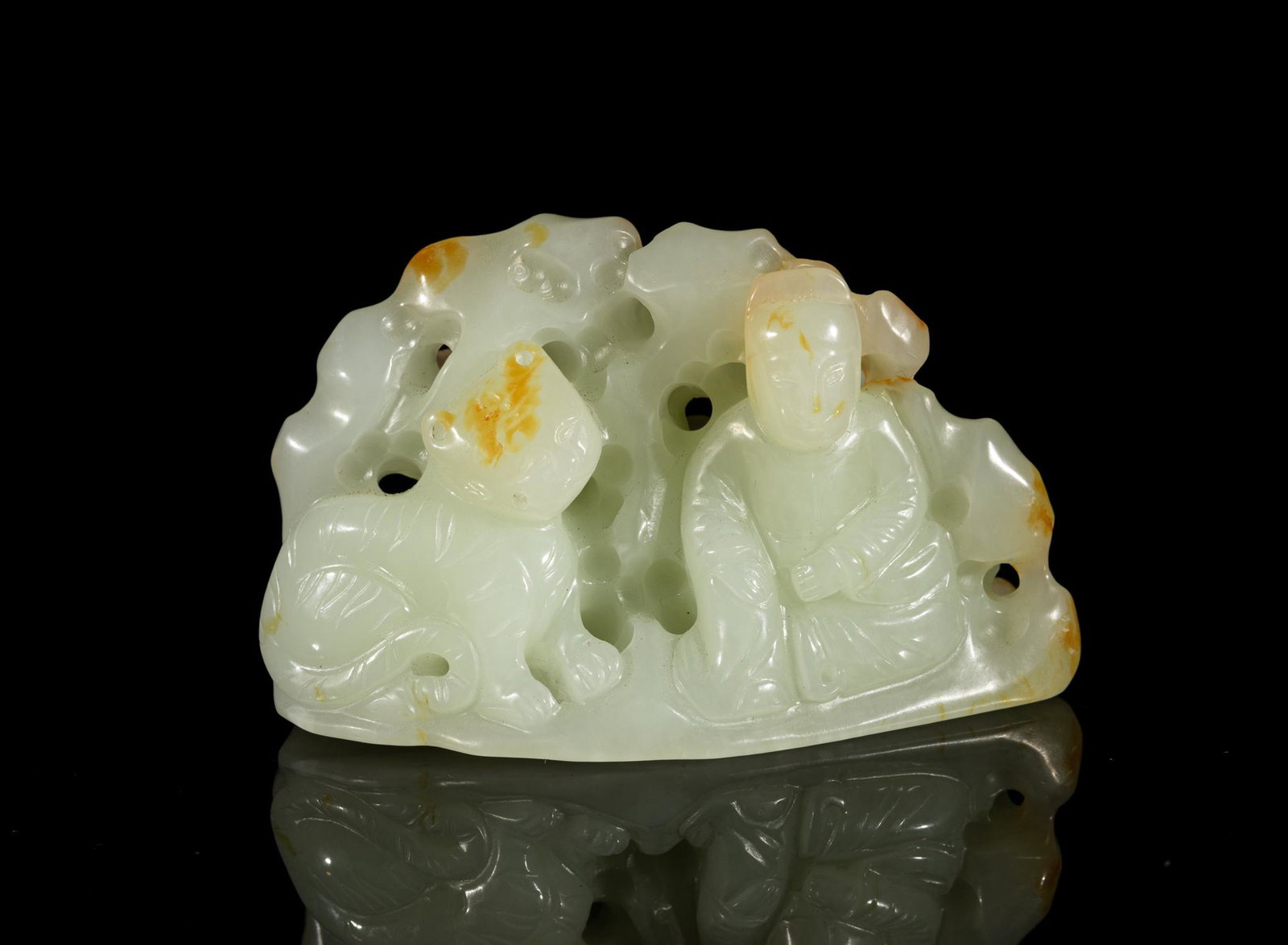 Chinese Russet Jade Table Sculpture: Deftly carved and pierced with a seated figure and a crouching tiger in front of craggy rockwork and gnarled tree, the stone in a warm white tone with russet inclusions. 3.15inch L, 1.6inch W, 1.9inch