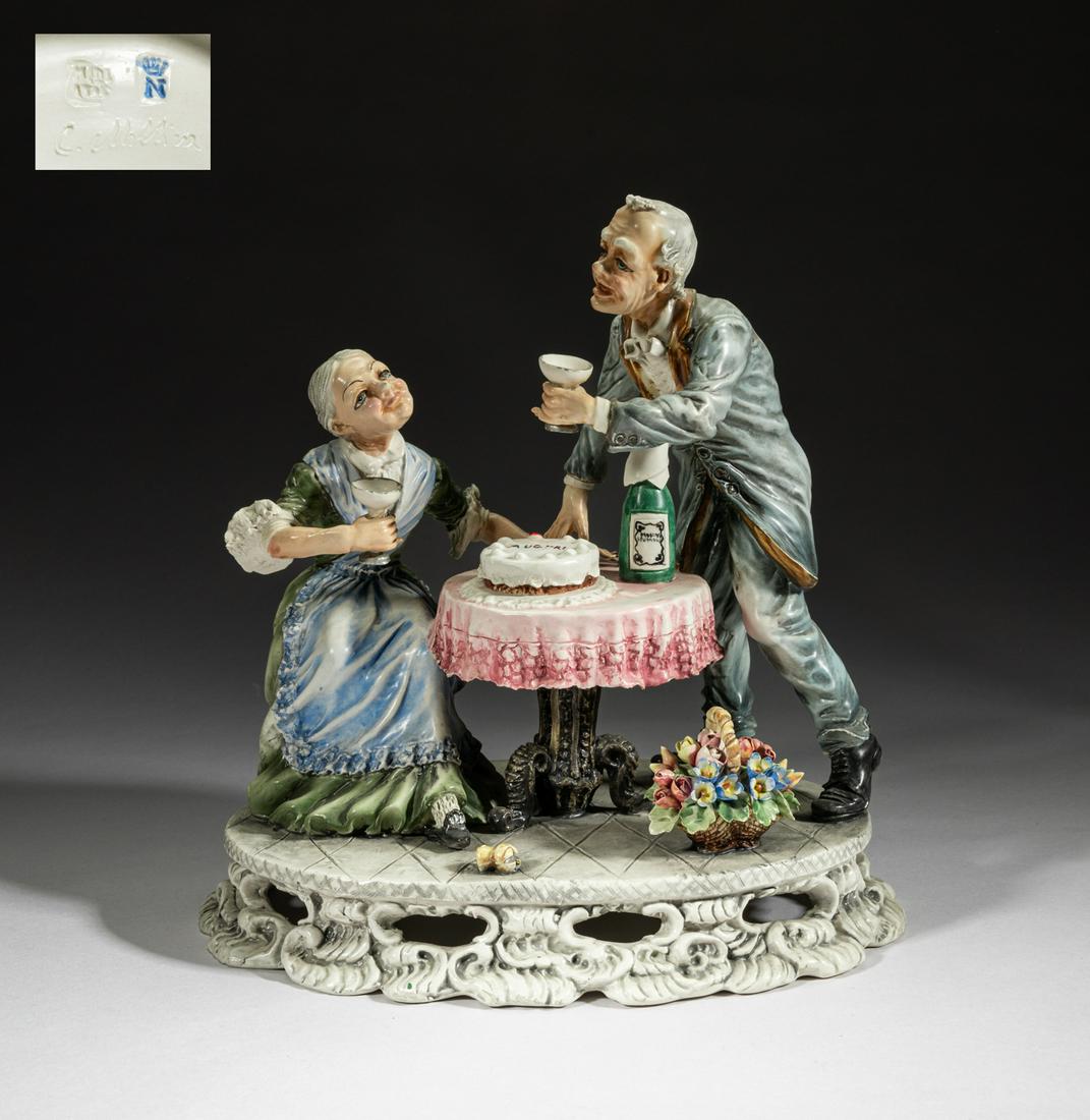 Capodimonte Italian Porcelain Sculpture: Modeled as an old man and an old woman cheering together, with a cake and a bottle on the table and a basket of flowers on the ground, the bottom marked C. Cllolliw. 10inch L, 7inch W. 9.8inch H.