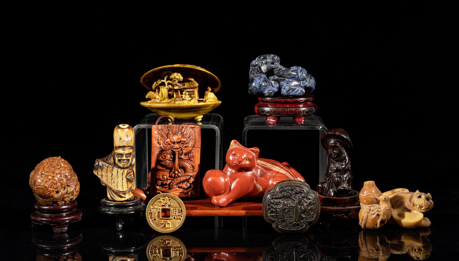 Japanese Horn, Netsuke & Sculptures: Including a netsuke carved dragons among clouds, a chestnut carved Luohan, a shell type decor carved with landscape inside, a coin type decor, a pierced pendant carved with figures in landscape, and s