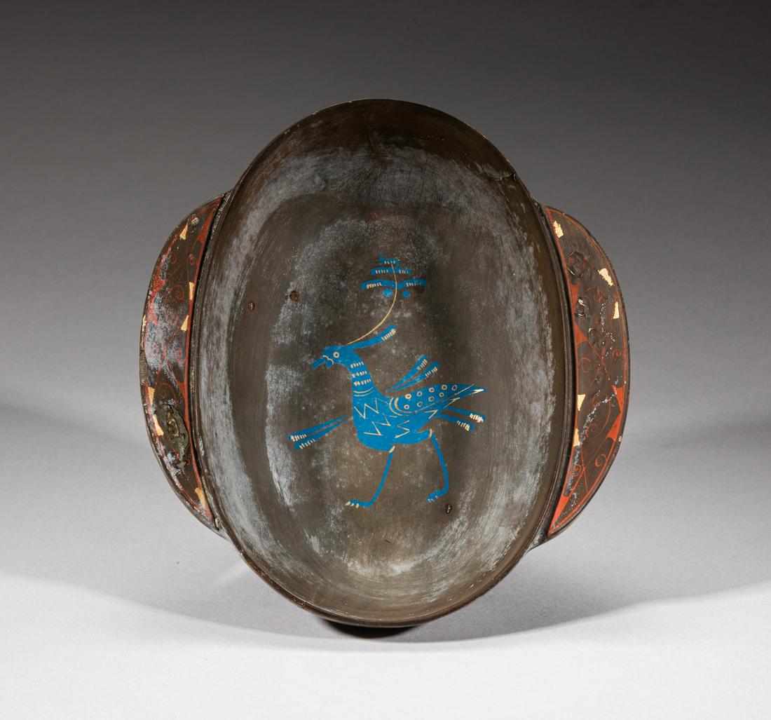 Chinese Han Type Lacquer Cup: Of oval form with a pair of gently upright handles, the interior painted with a stylized bird in blue and golden colors. 7.1inch L, 6.1inch W, 2.1inch H. The Estate of the Richard. F. T & Son, England