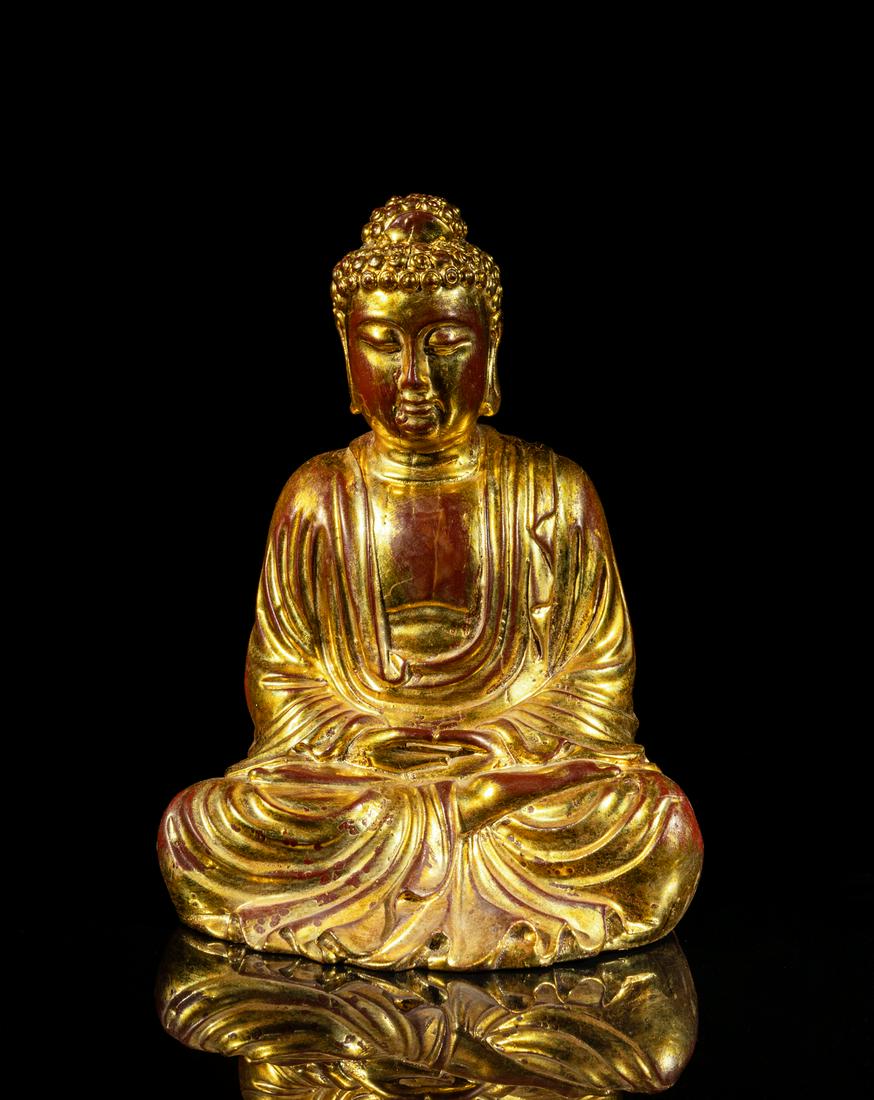 Chinese Gilt Wood Buddha: Carved seated in dhyanasana with the hands held in dhyana mudra, wearing a long flowing robe open at the chest, the face with serene expression and the hair in tight curls covering the ushnisha. 8.5in