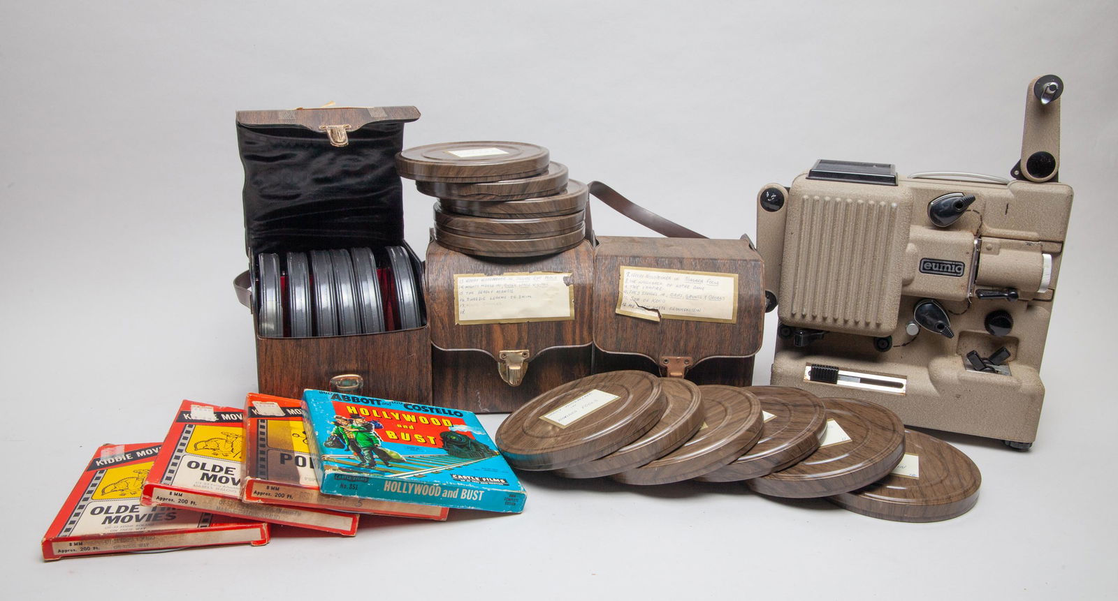 Set Vintage Films & Projector Collection: A large group of vintage films and a projector. Size varies.