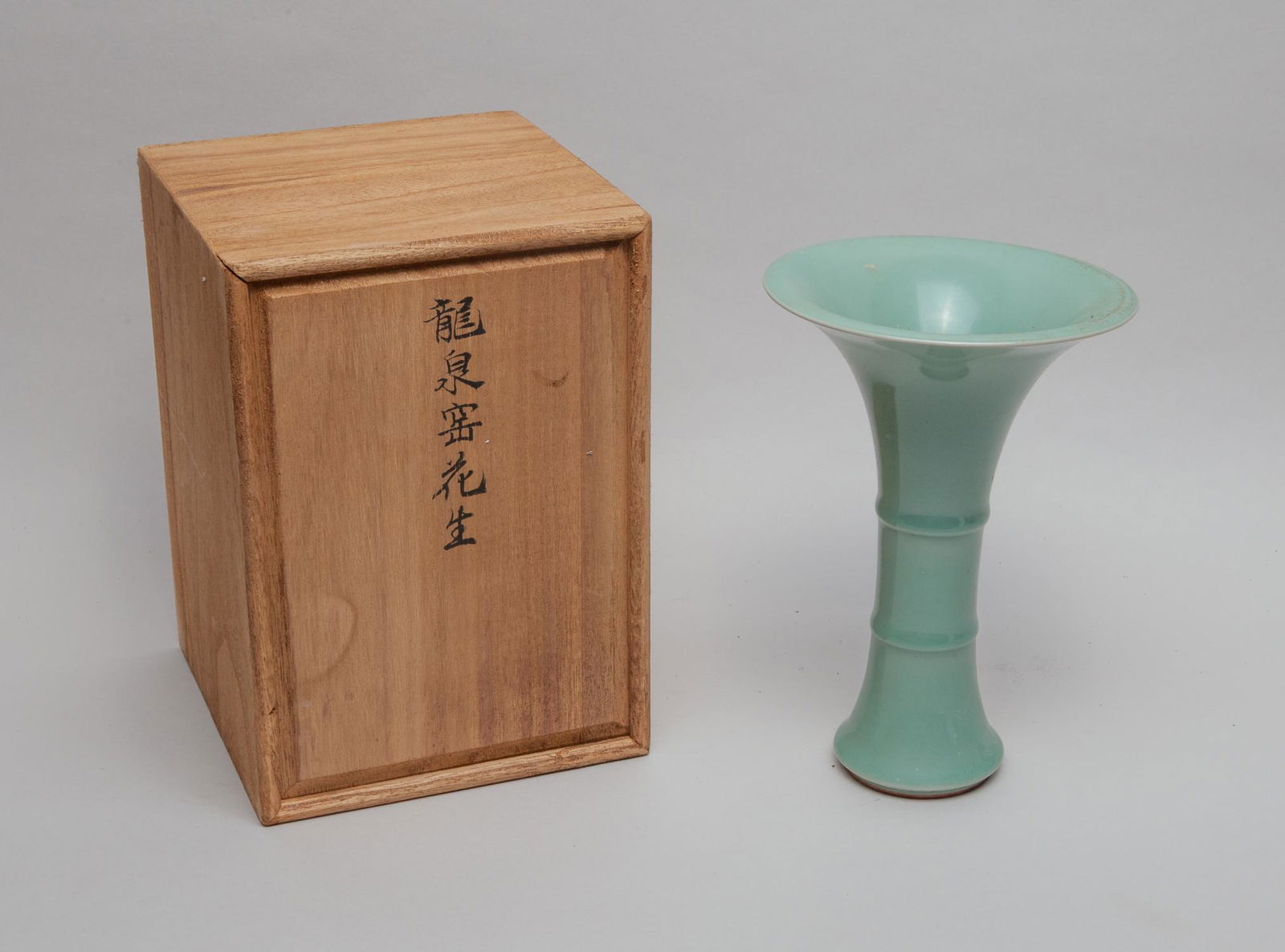 Chinese Celadon Glazed Porcelain Vase.: The gently waisted body rising to a flaring mouth, covered overall with a soft celadon glaze, with box. Approx. 8inch H, 5.5inch W (w/o box).