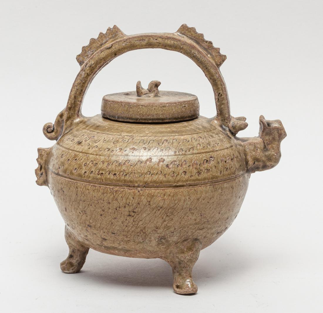 Chinese Yue Ware Porcelain Pot: Of compressed globular form supported on three cabriole legs, the exterior carved in low relief with scrolls and applied with a mottled brownish olive-green glaze suffused with a network of crackles, 