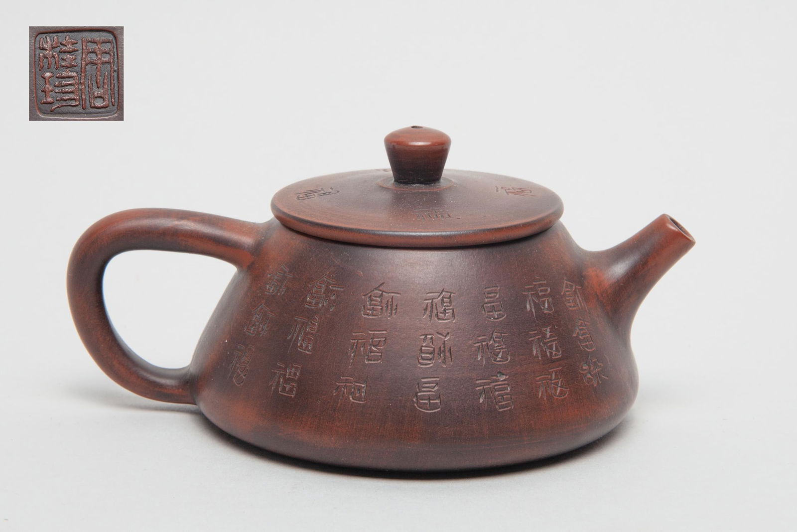 Vintage Chinese Zisha Tea Pot: The body and cover exterior inscribed with stylized Chinese Fu characters, the cover interior incised with two marks and the bottom with a seal mark. 5.1inch L, 3.7inch W, 2.4inch H.