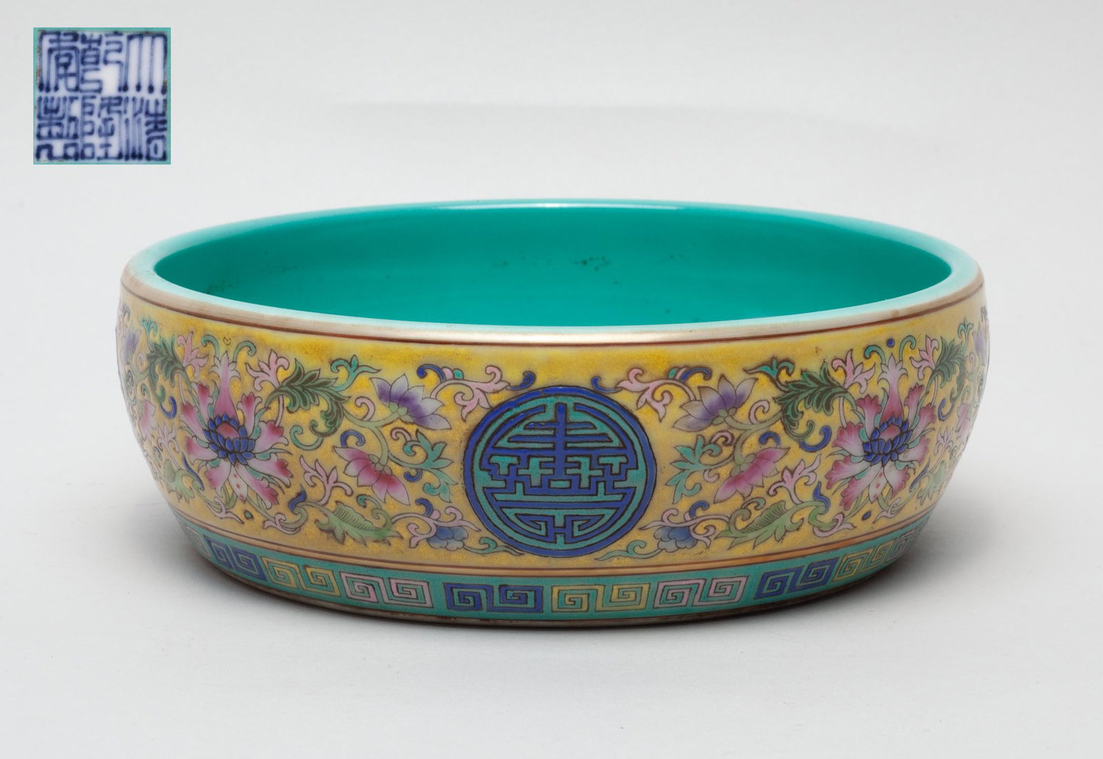 Chinese Famille Rose Porcelain Washer: The sides enameled with circular shou characters among lotus sprays on a yellow ground above a fret band, the interior and bottom glazed in turquoise tone, inscribed with a six-character mark on the b