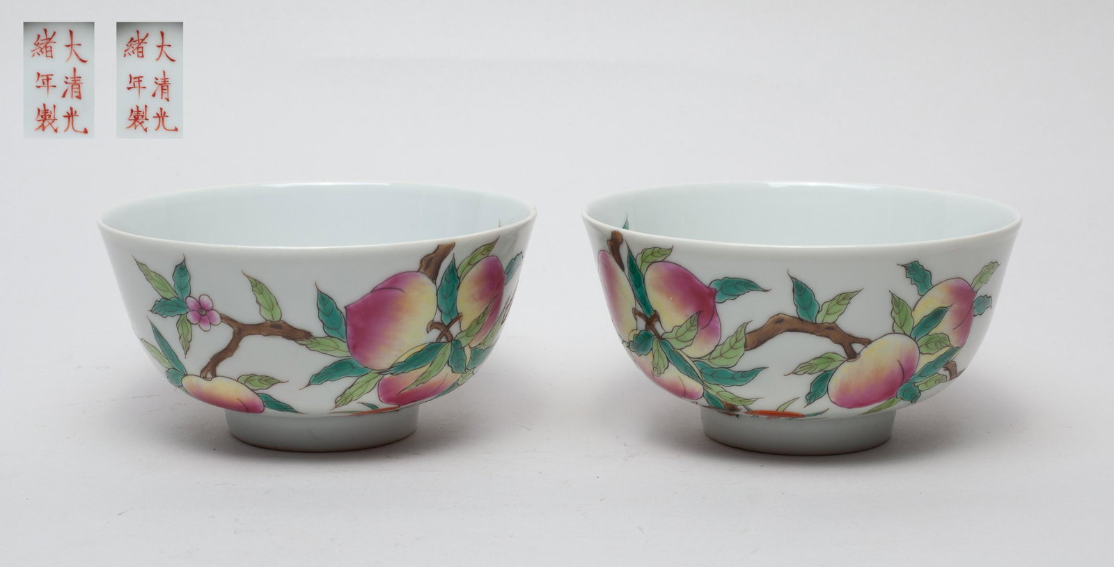 Pair Chinese Famille Rose Porcelain Bowls: Each brightly enameled with flowering and fruiting peach branches issuing from the exterior foot and extending over the rim onto the interior, interspersed with lingzhi and two bats, the bottom marked
