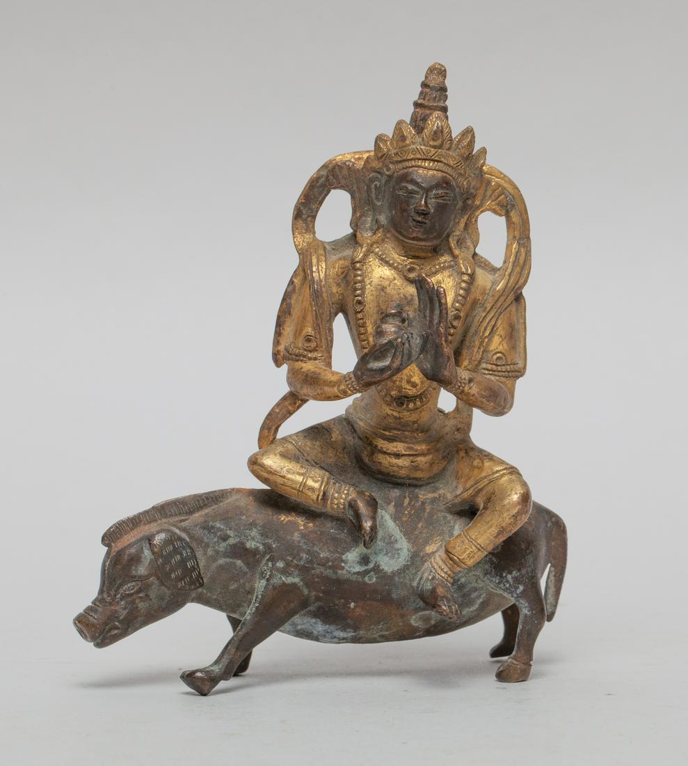 Chinese Sino-Tibetan Gilt Bronze Buddha: Cast as Buddha seated on a pig, the left hand in abhaya mudra and right hand holding an implement, the face with serene expression framed by a crown and a pair of pendulous ears. 3.9inch H, 3.3inch W,