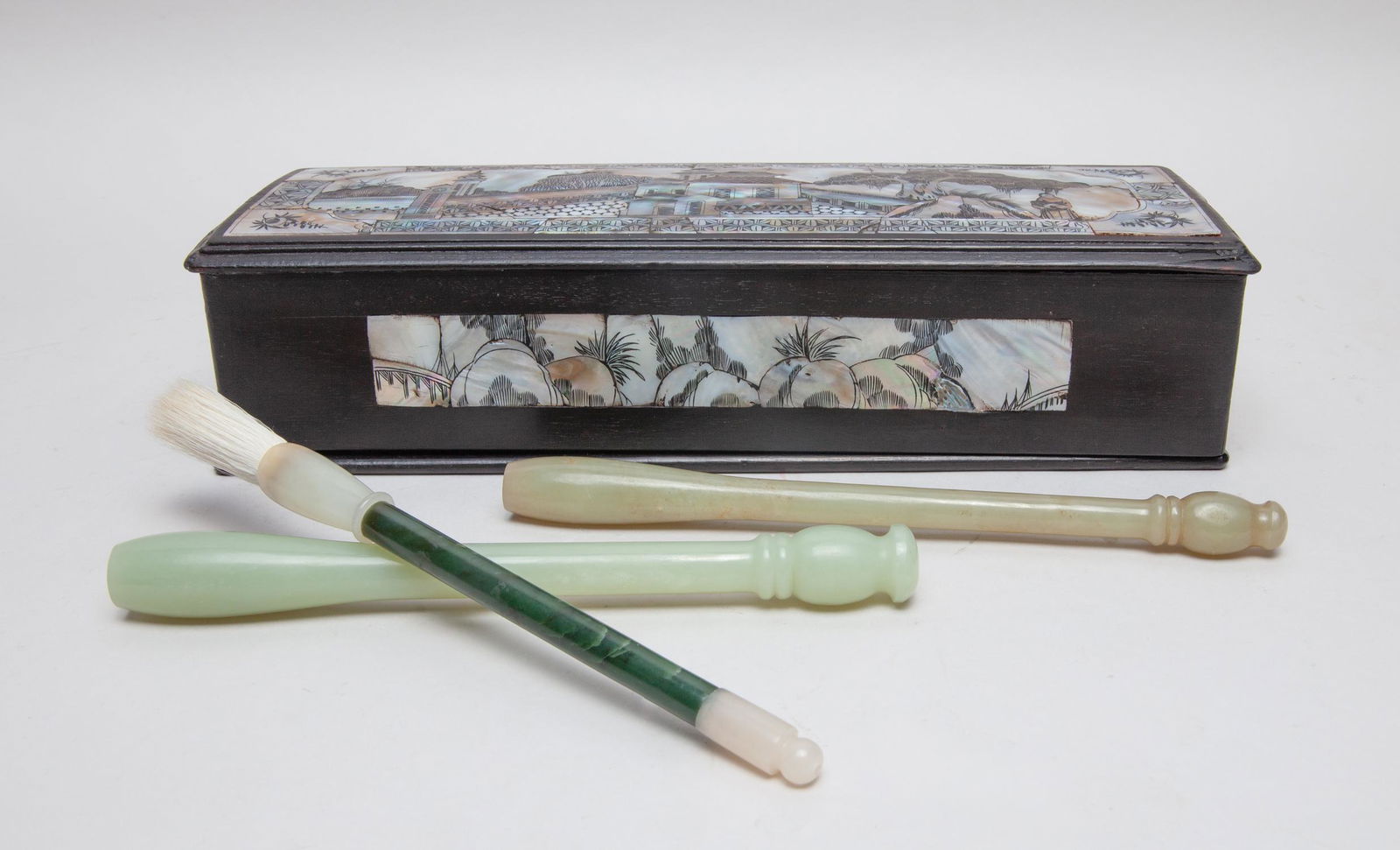 Rare Chinese Jade Brush Pen w/ MOP Box: Group of three Chinese jade brush pens, the stone in pale celadon, yellow celadon or spinach green tones, with a wood box inlaid with mother of pearl as landscape. 8.6inch L (largest pen).