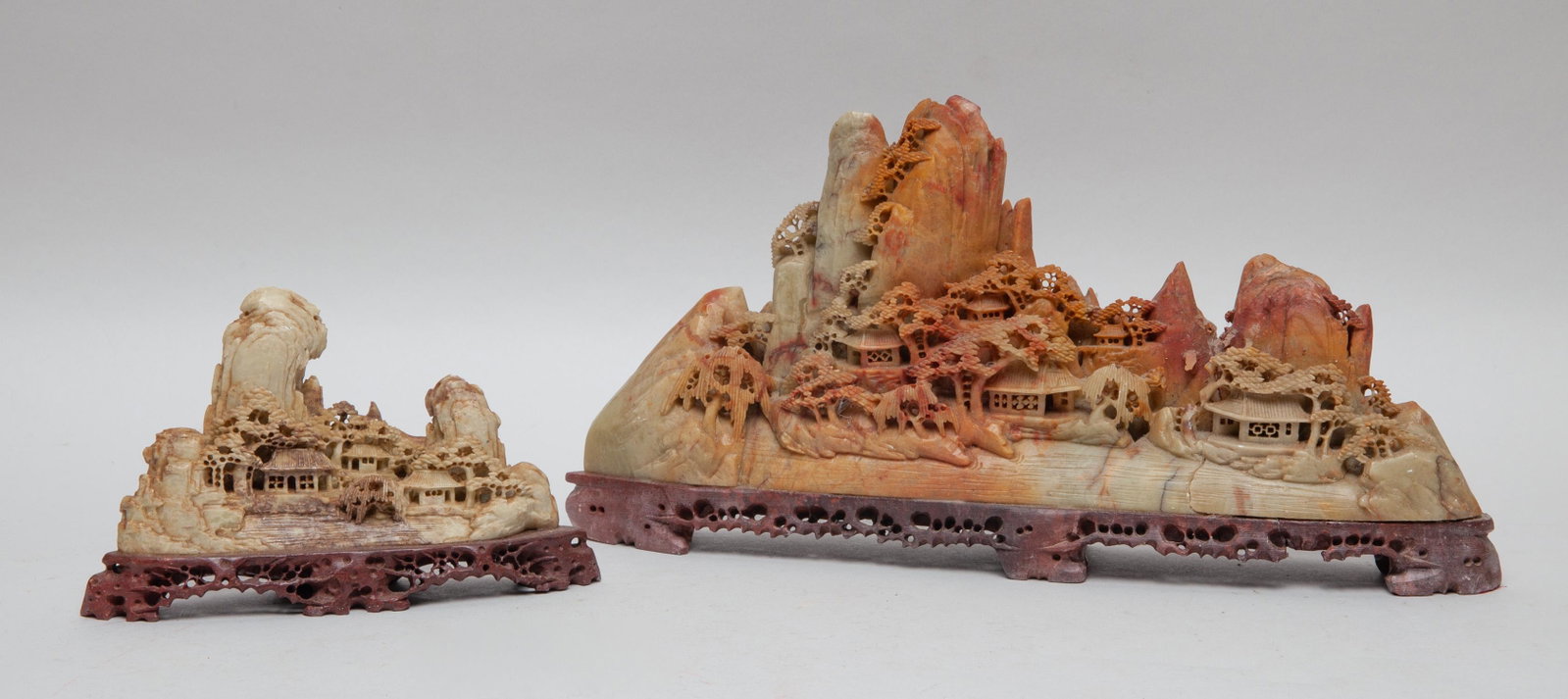 Two Chinese Stone Sculptures: Both carved and reticulated with mountainous landscape, the stone in variegated russet and yellow-green tone. 13inch L, 2.3inch W, 6.2inch H (larger).